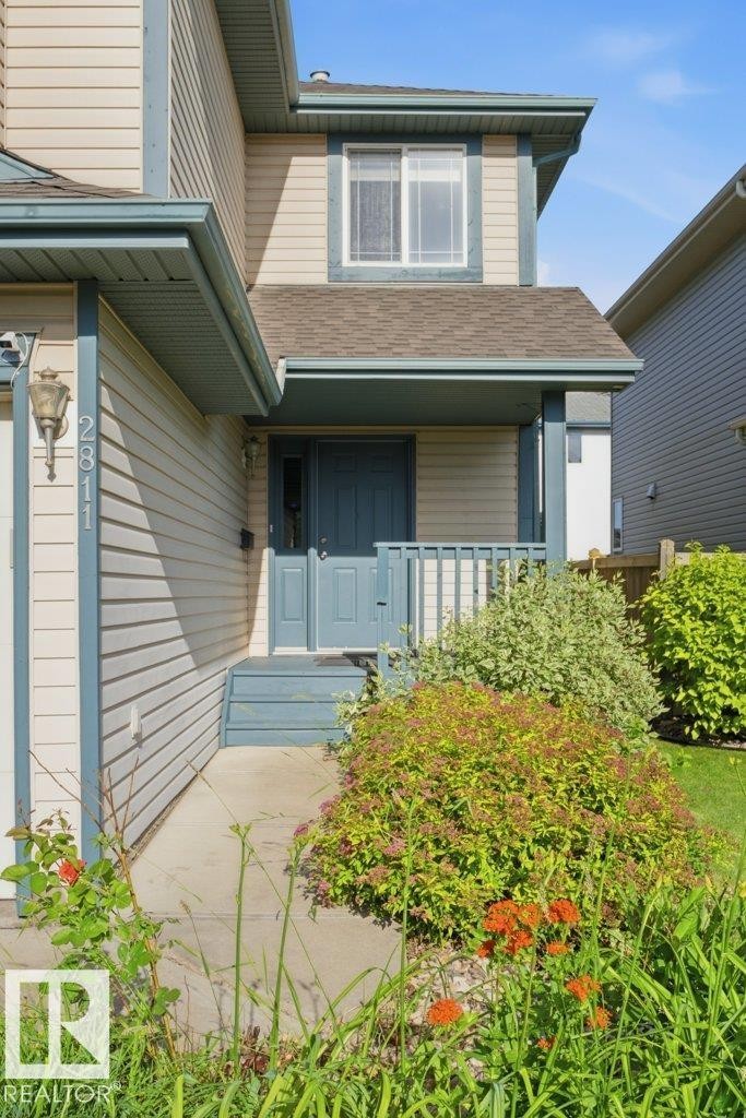 Property exterior featuring horizontal siding, a covered entry porch, and a second-story window - 2811 33 Street, Edmonton, AB