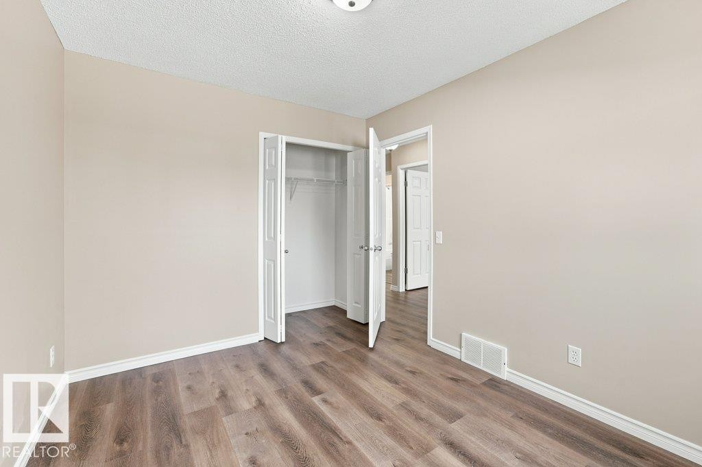 Room featuring wood-finish flooring, neutral wall tones, and white trim - 2811 33 Street, Edmonton, AB