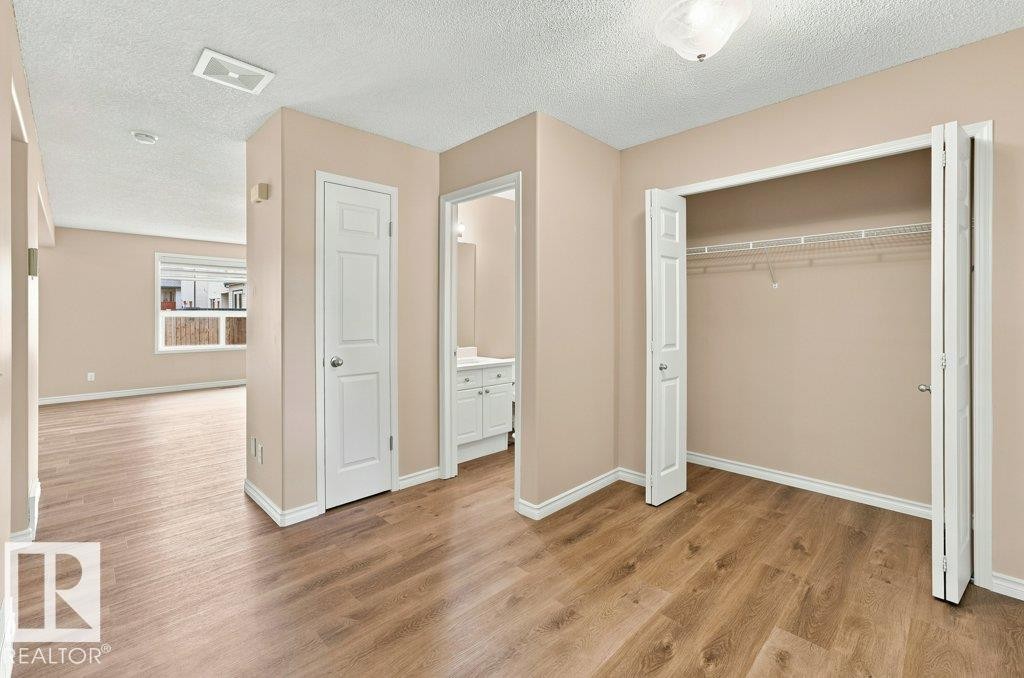 Spacious room featuring wood-finish flooring and a neutral color palette - 2811 33 Street, Edmonton, AB
