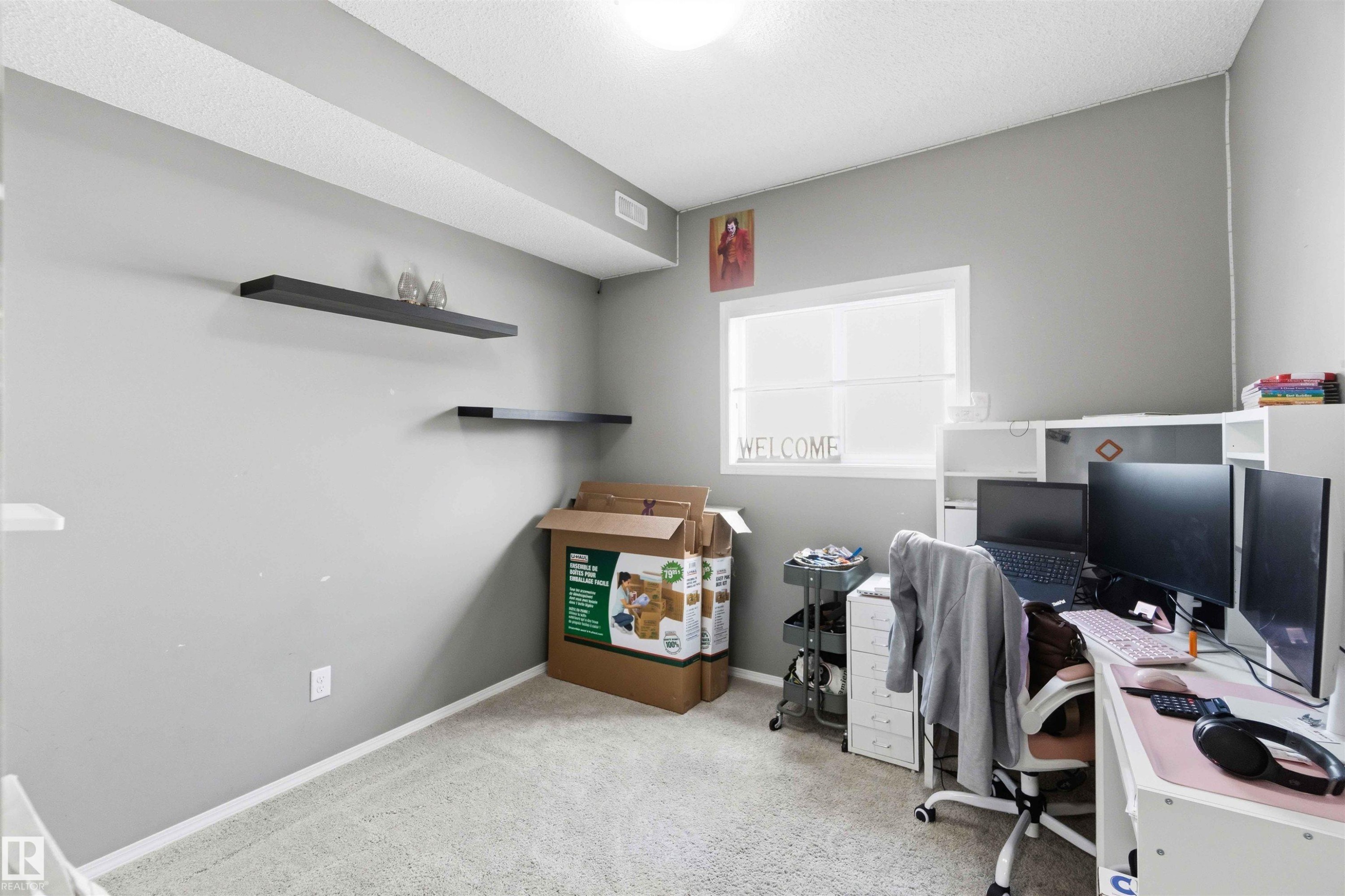 Carpeted room with light grey walls and a single window - 24 6520 2 Avenue, Edmonton, AB
