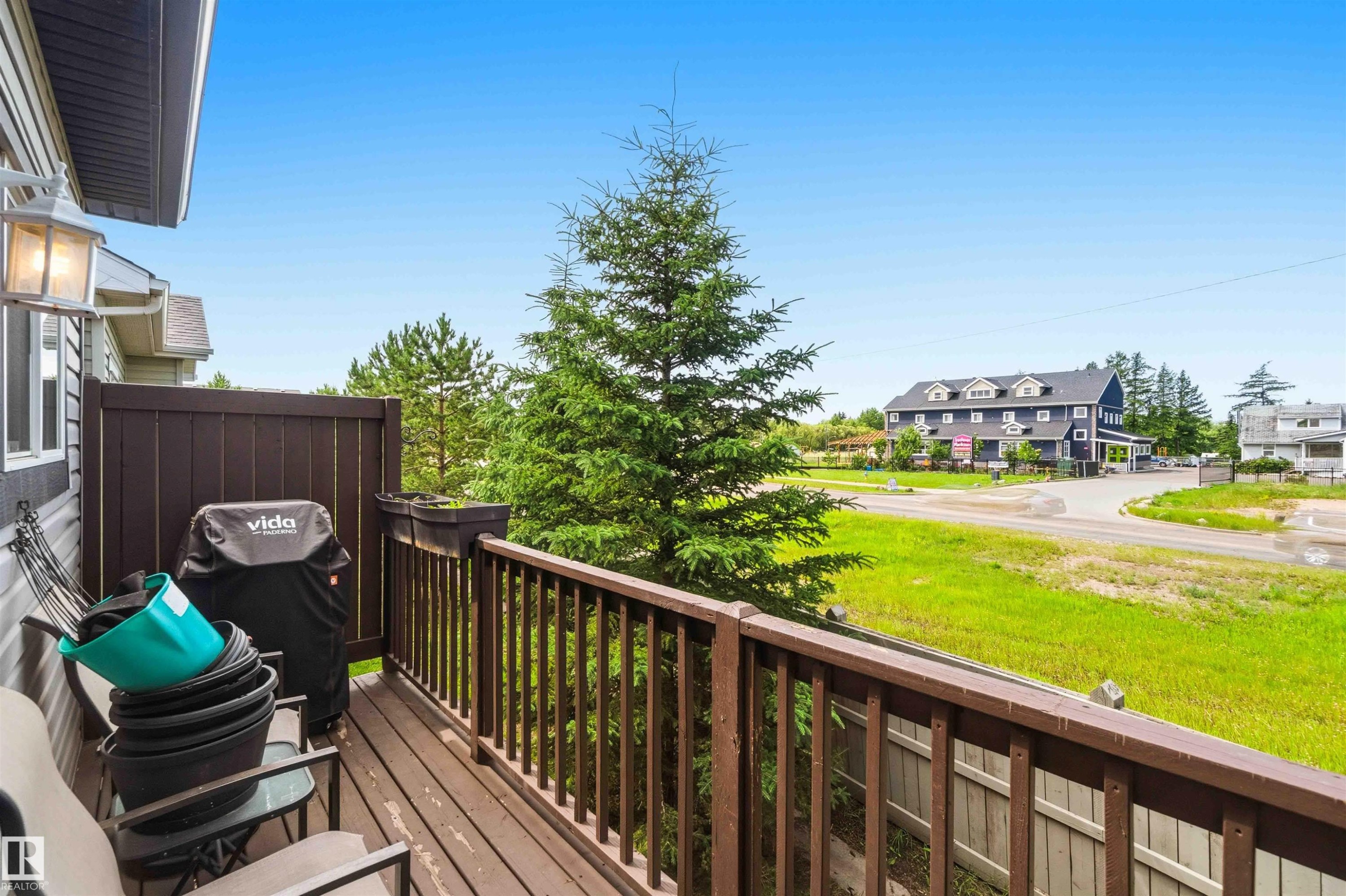 Exterior deck featuring wood-finish flooring, a wood railing, and a privacy fence - 24 6520 2 Avenue, Edmonton, AB