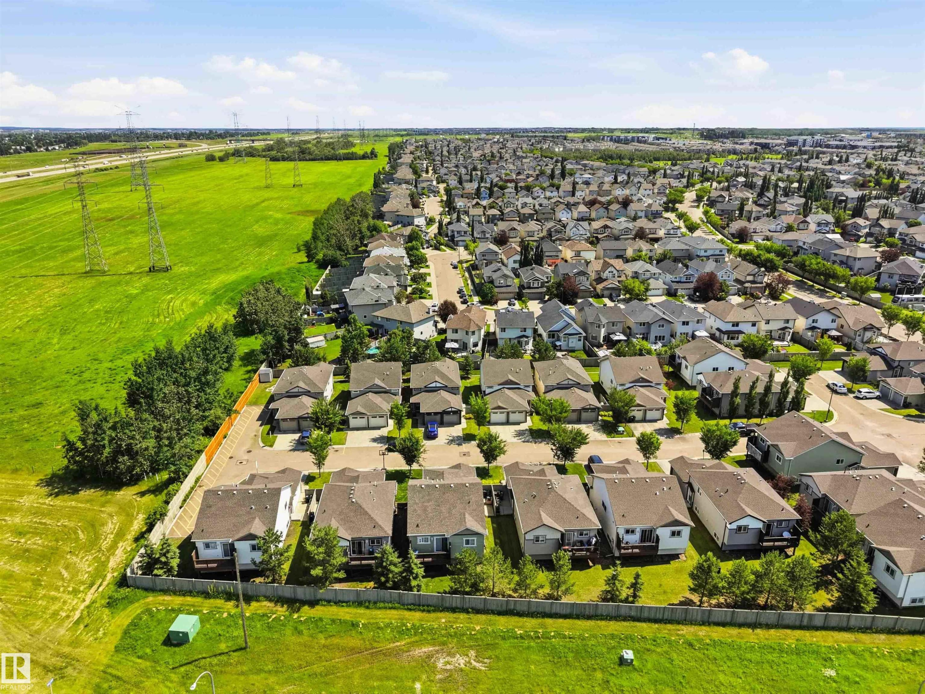 Aerial perspective showcasing a residential development bordered by open green spaces - 24 6520 2 Avenue, Edmonton, AB