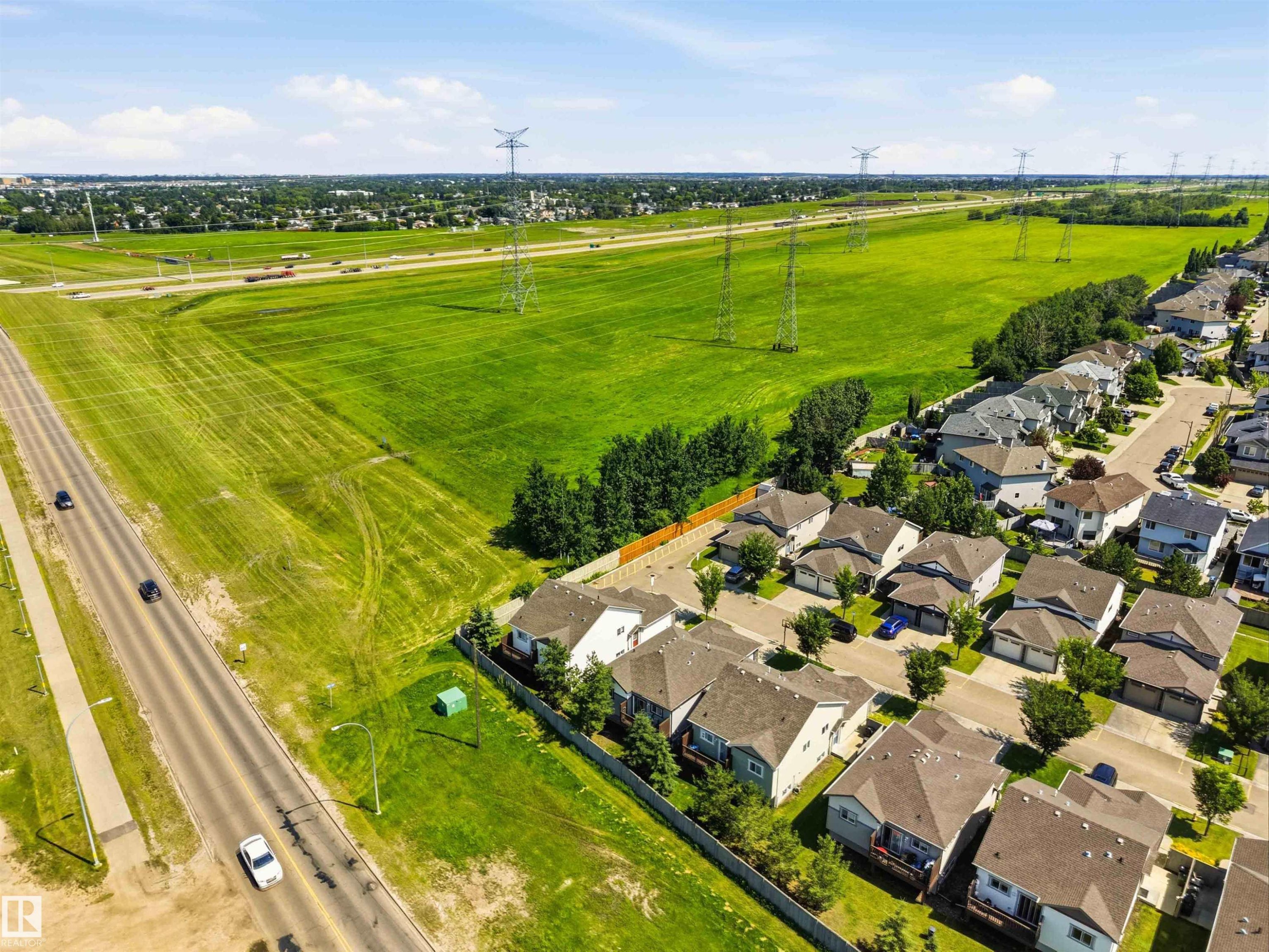 Residential community with multiple detached properties, featuring a paved street and abundant green space - 24 6520 2 Avenue, Edmonton, AB