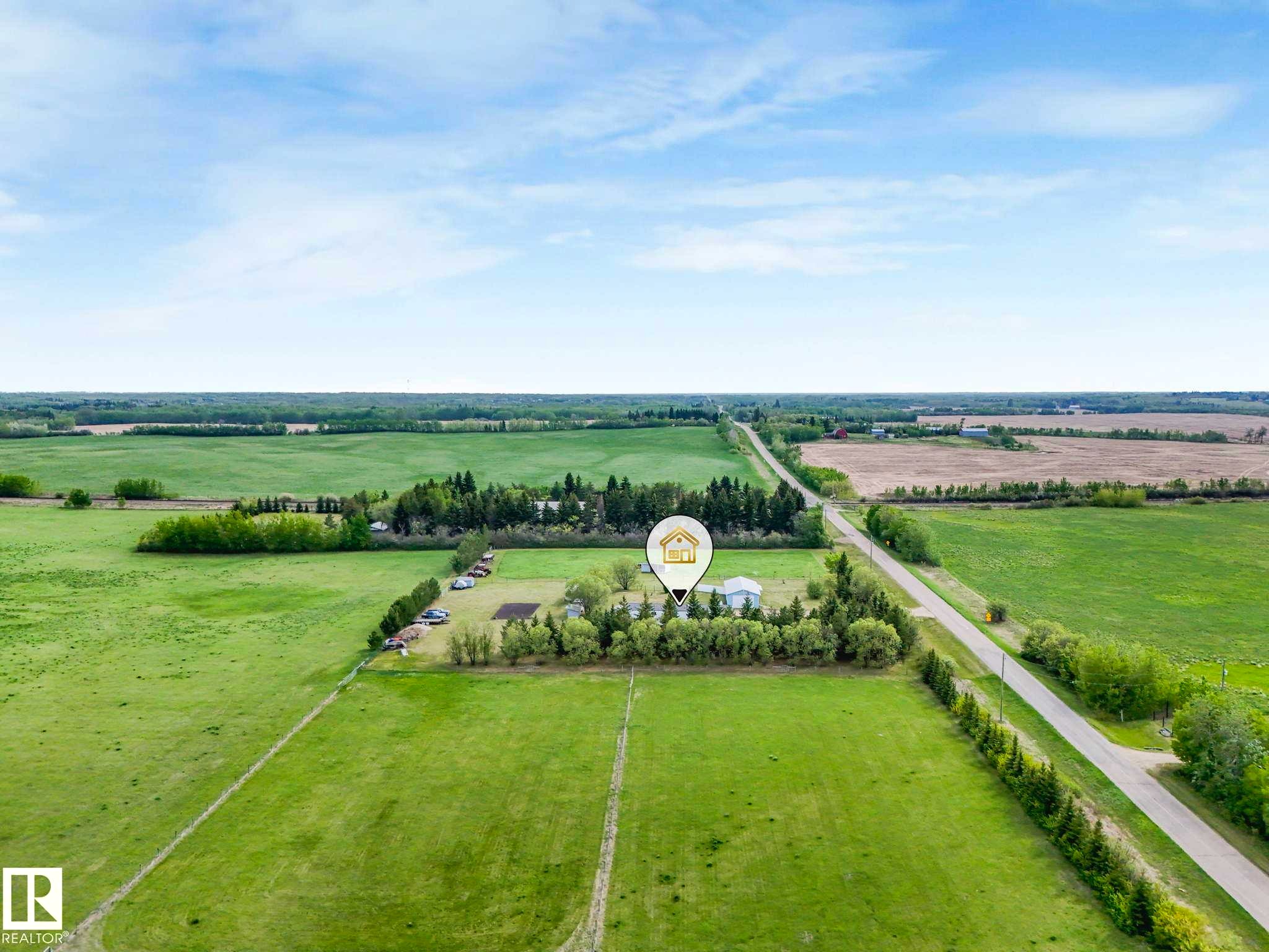 Expansive rural property featuring an established treeline, cultivated fields, and a paved road frontage - 53133 Rge Road 223, Rural Strathcona County, AB - Outdoor With View