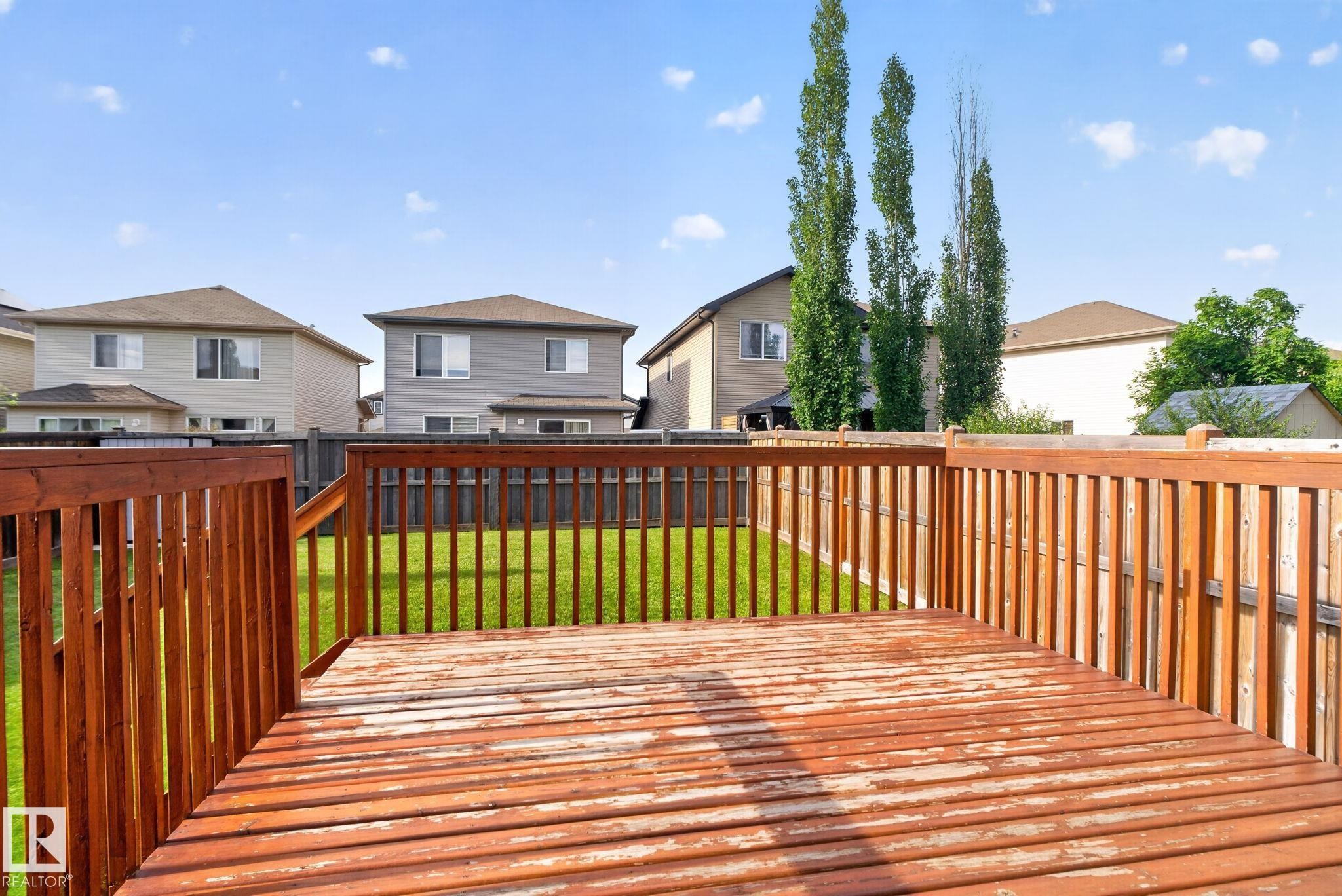 Expansive wood deck with a full railing and balusters - 7858 170A Avenue, Edmonton, AB