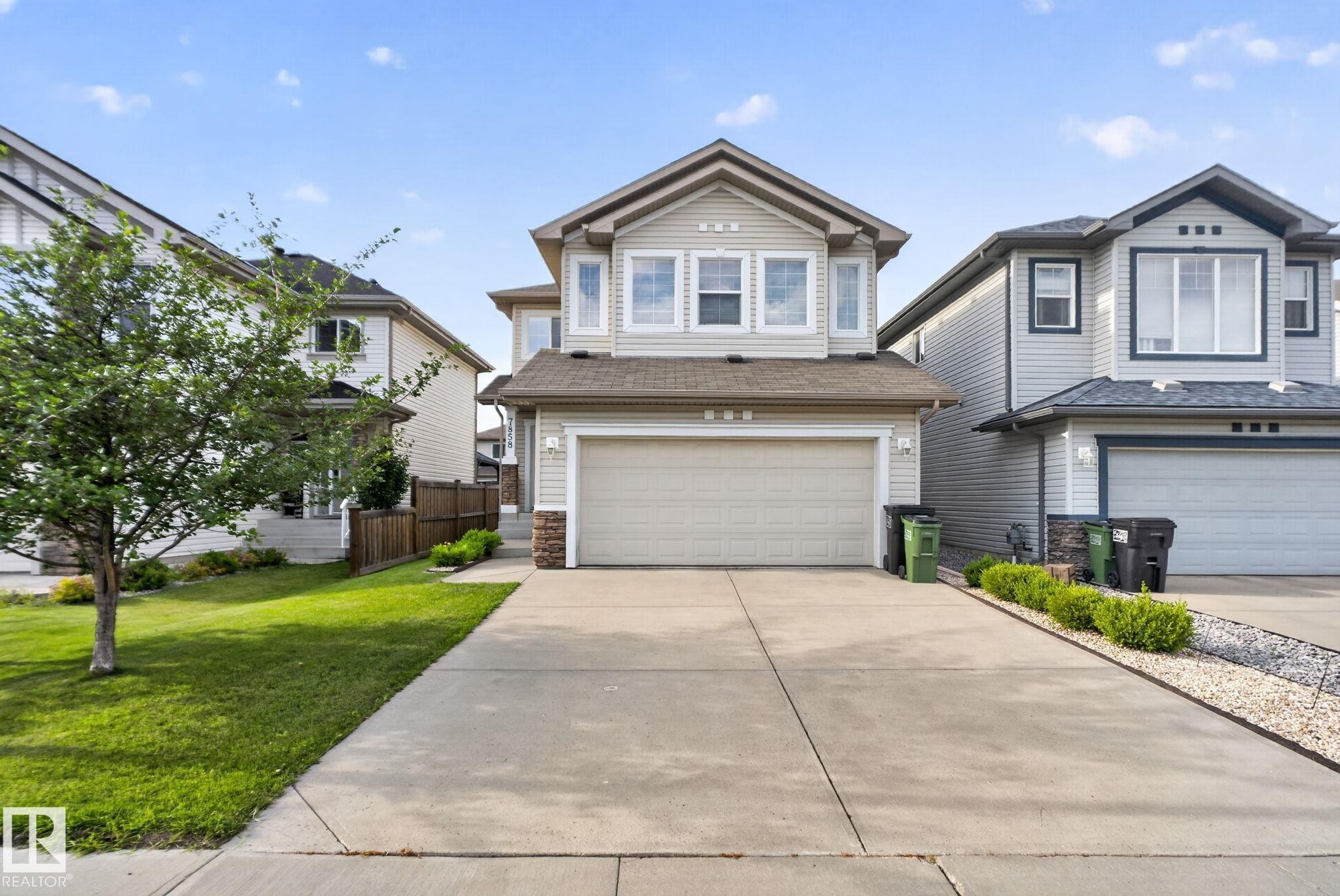 Contemporary two-story residence featuring light-toned siding and a prominent front-facing garage - 7858 170A Avenue, Edmonton, AB