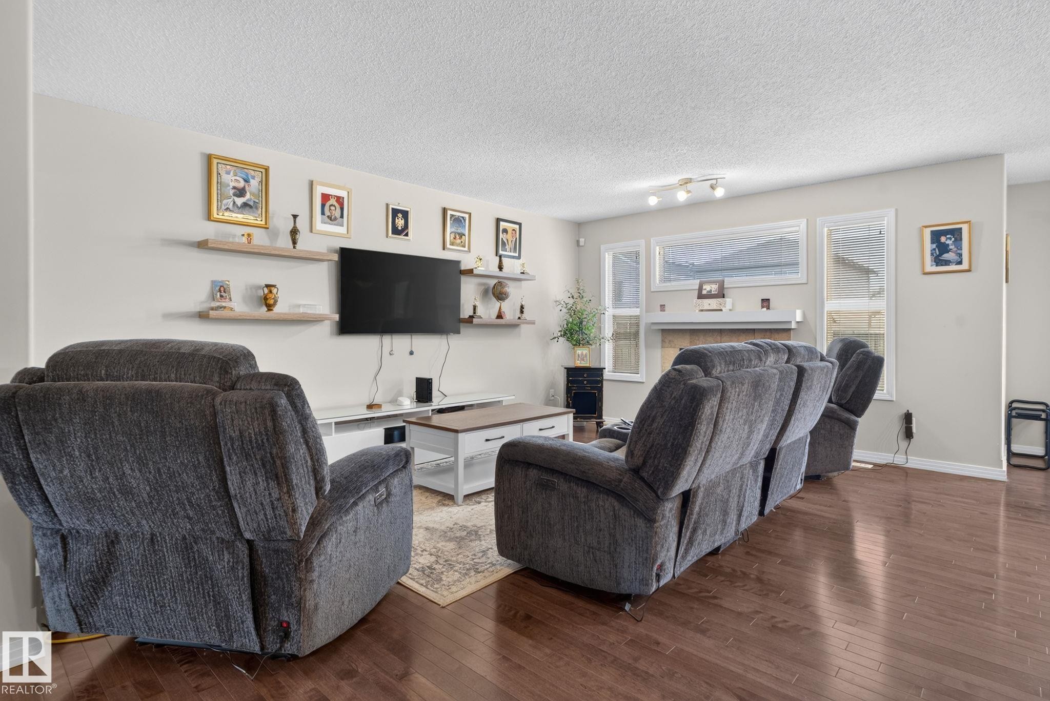 Hardwood-finish flooring throughout the main living area, featuring light-toned wall paint and white trim - 7858 170A Avenue, Edmonton, AB