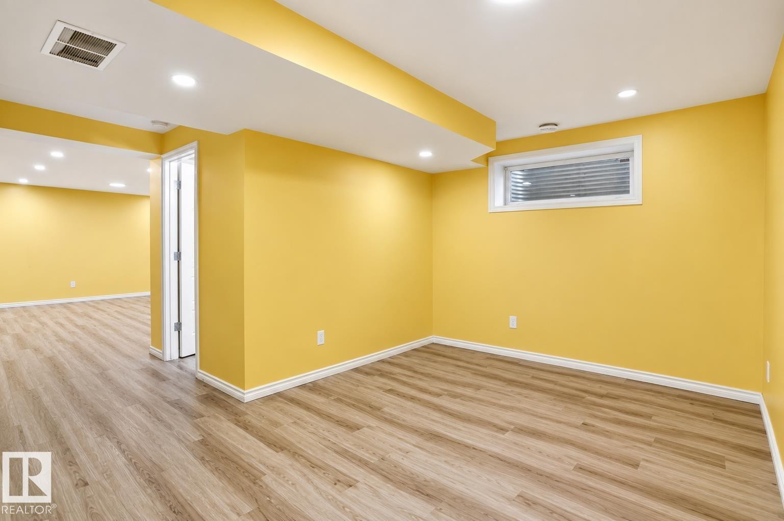 Spacious room with wood-finish flooring, recessed lighting, a white trim package, and a high-set window - 445 Watt Boulevard Sw, Edmonton, AB - Indoor Photo Showing Other Room