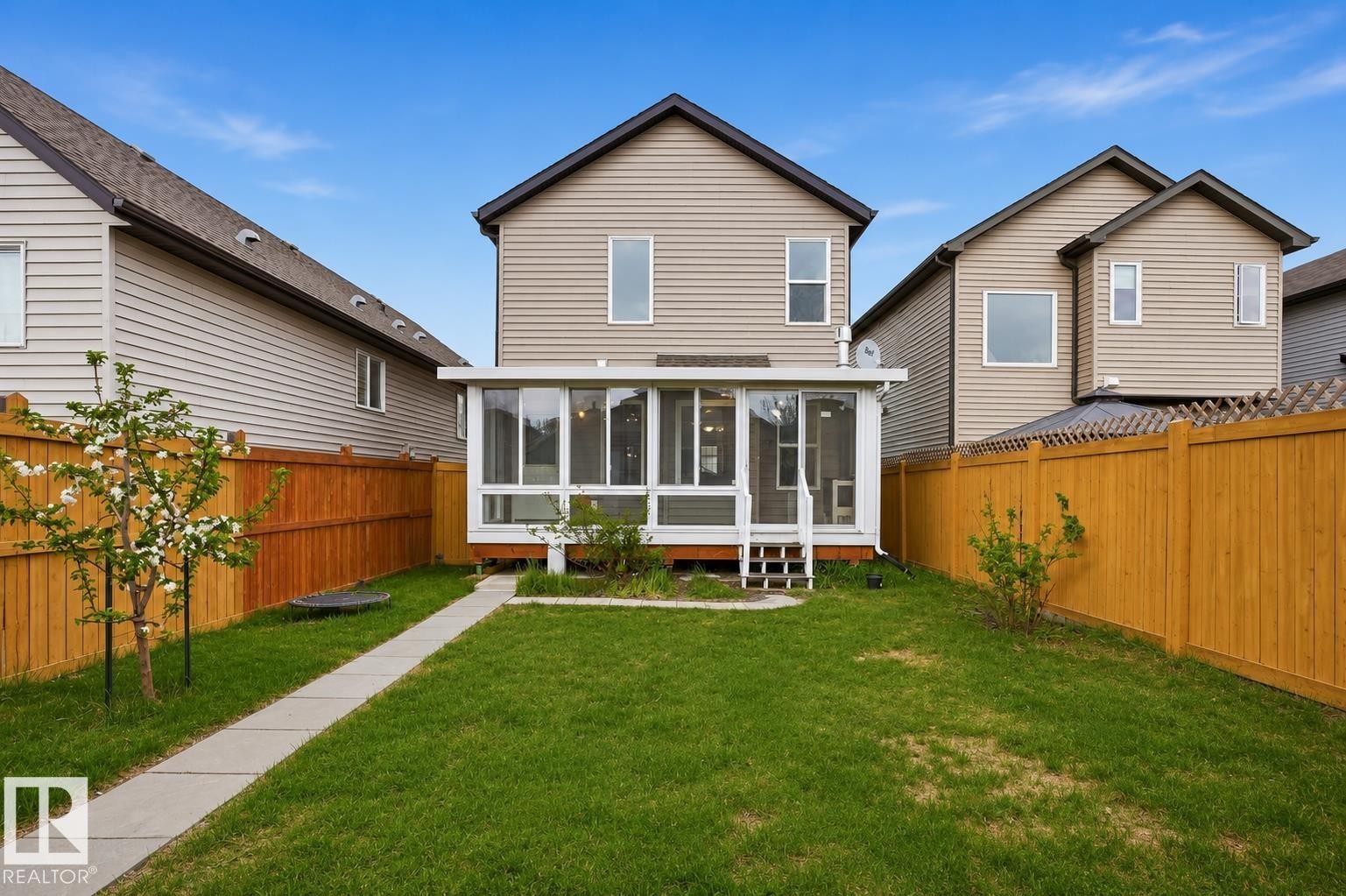 Rear exterior of a two-story residence featuring light-colored siding and a dark shingle roof - 445 Watt Boulevard Sw, Edmonton, AB - Outdoor With Deck Patio Veranda