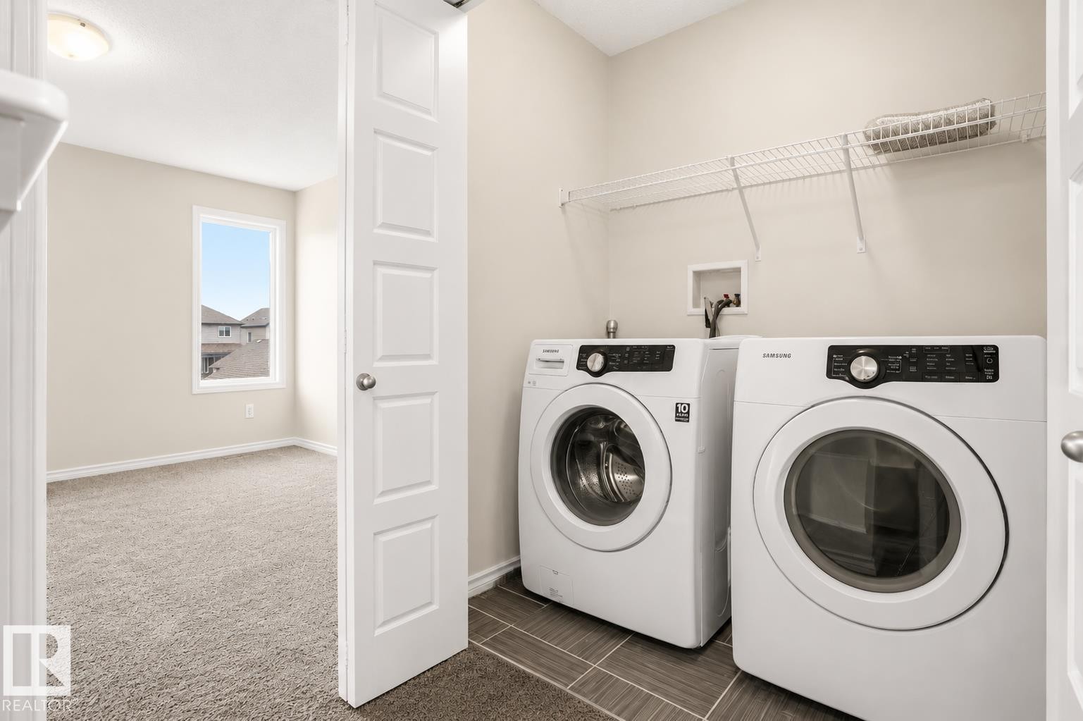 Dedicated laundry space featuring a tile floor, white wire shelving, and connections for a washer and dryer - 445 Watt Boulevard Sw, Edmonton, AB - Indoor Photo Showing Laundry Room