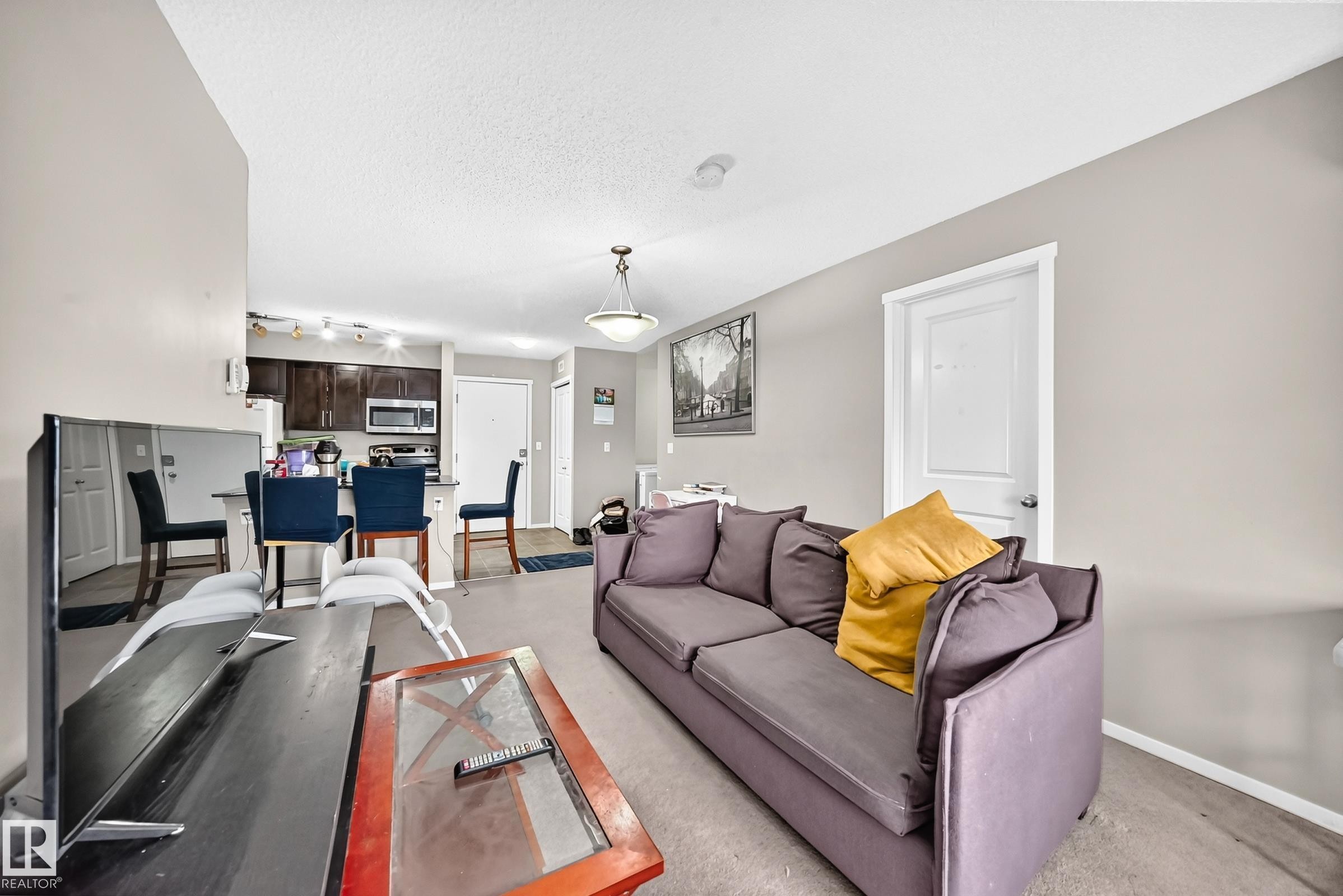 Open concept living area featuring light neutral walls and carpet flooring - #417 1510 Watt Dr Sw, Edmonton, AB - Indoor