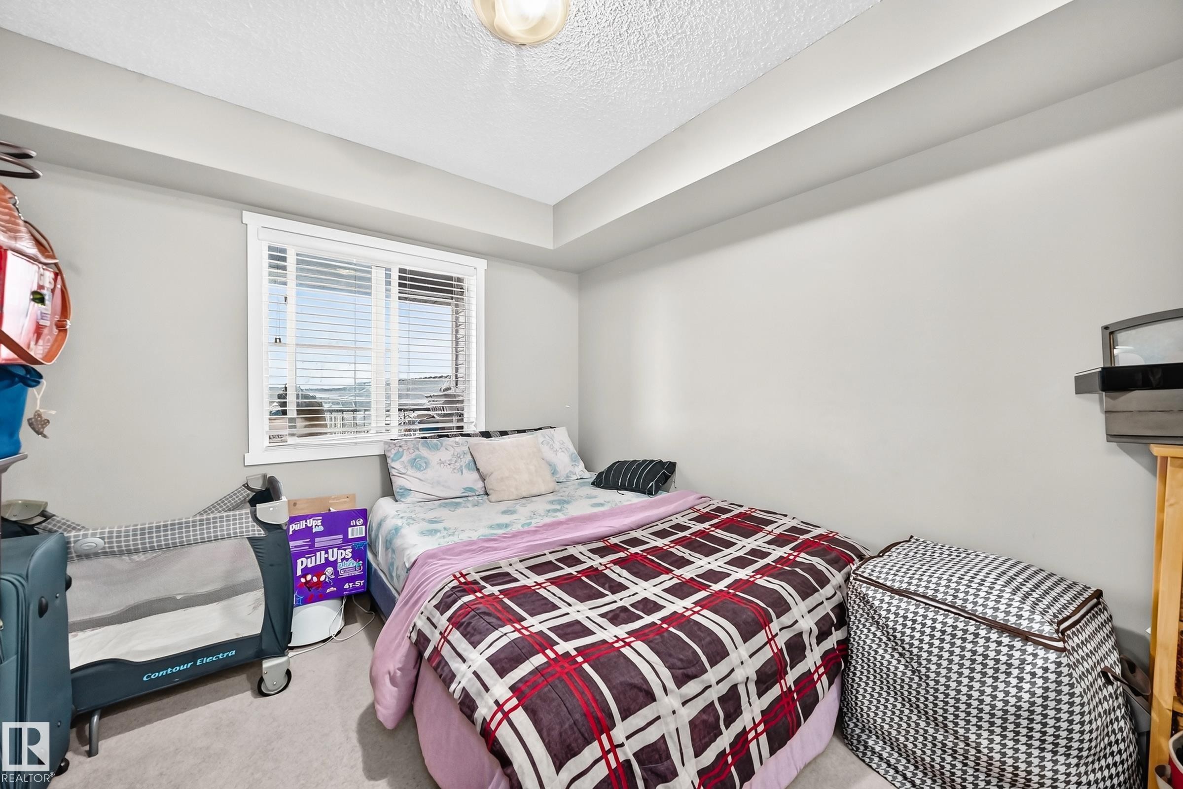 Room featuring light gray walls and carpet flooring - #417 1510 Watt Dr Sw, Edmonton, AB - Indoor Photo Showing Bedroom