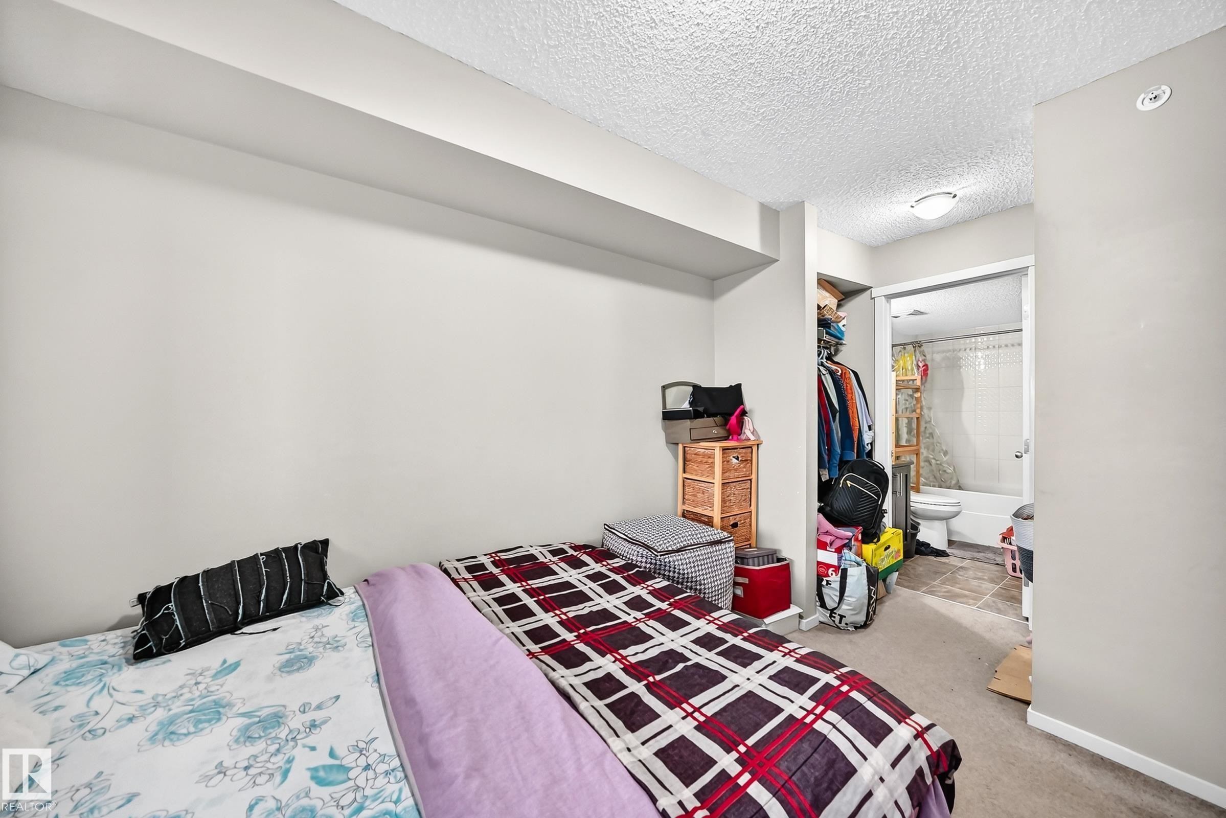 Carpeted room featuring light gray walls and a textured ceiling - #417 1510 Watt Dr Sw, Edmonton, AB - Indoor Photo Showing Bedroom