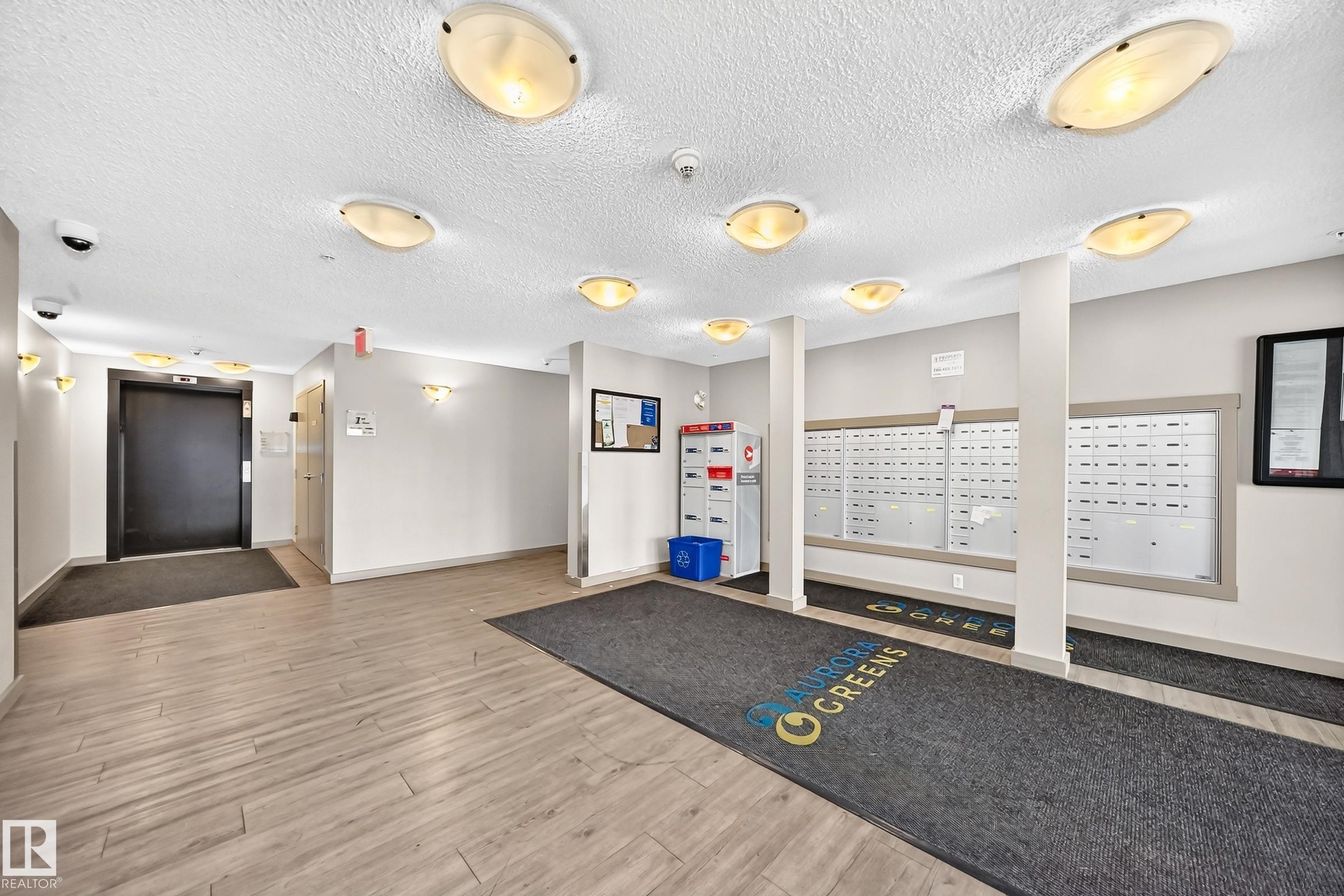 Building lobby featuring wood-finish flooring and recessed lighting - #417 1510 Watt Dr Sw, Edmonton, AB - Indoor Photo Showing Other Room