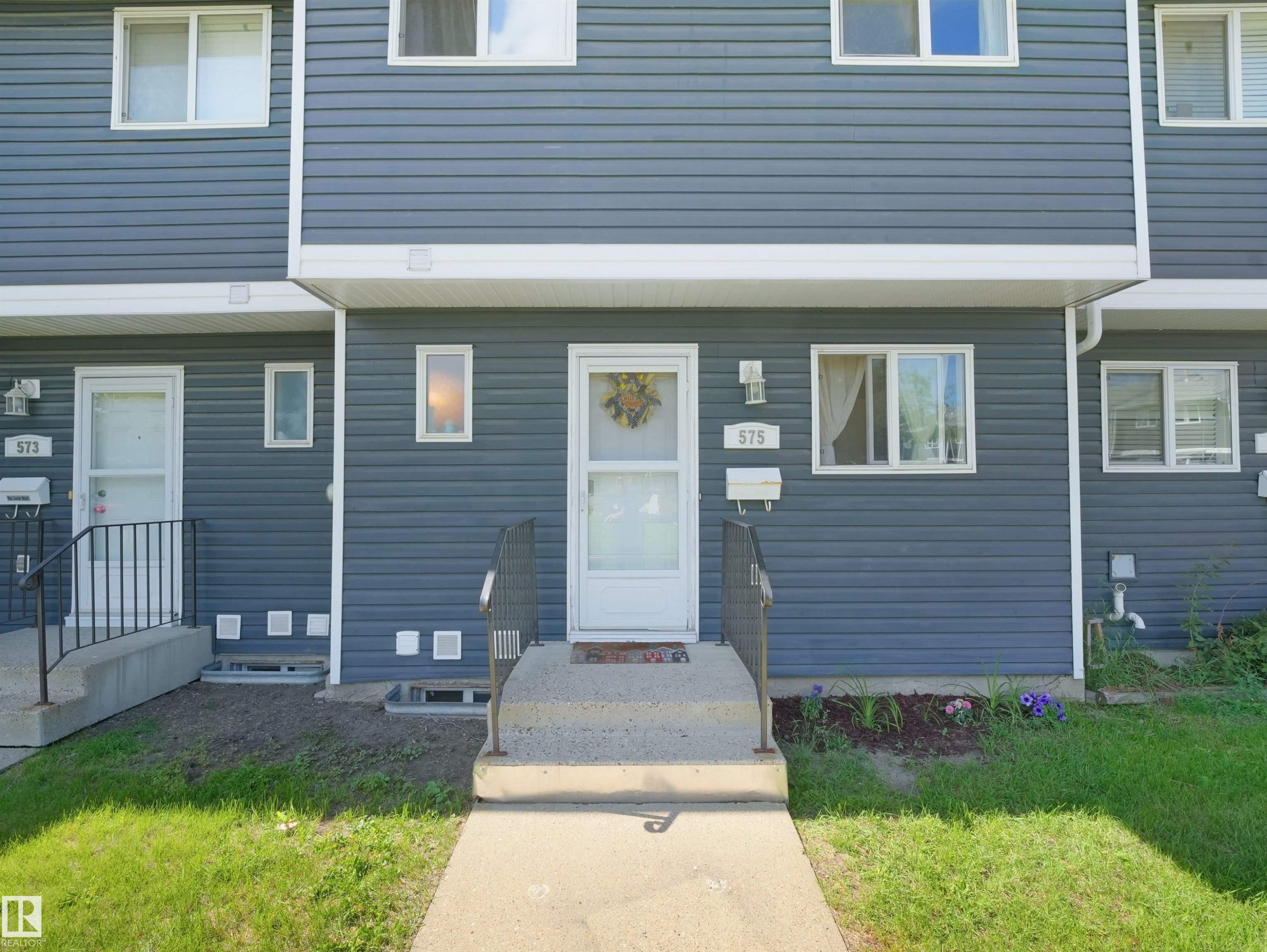 Townhome exterior featuring gray horizontal siding and white trim - 575 Dunluce Road, Edmonton, AB