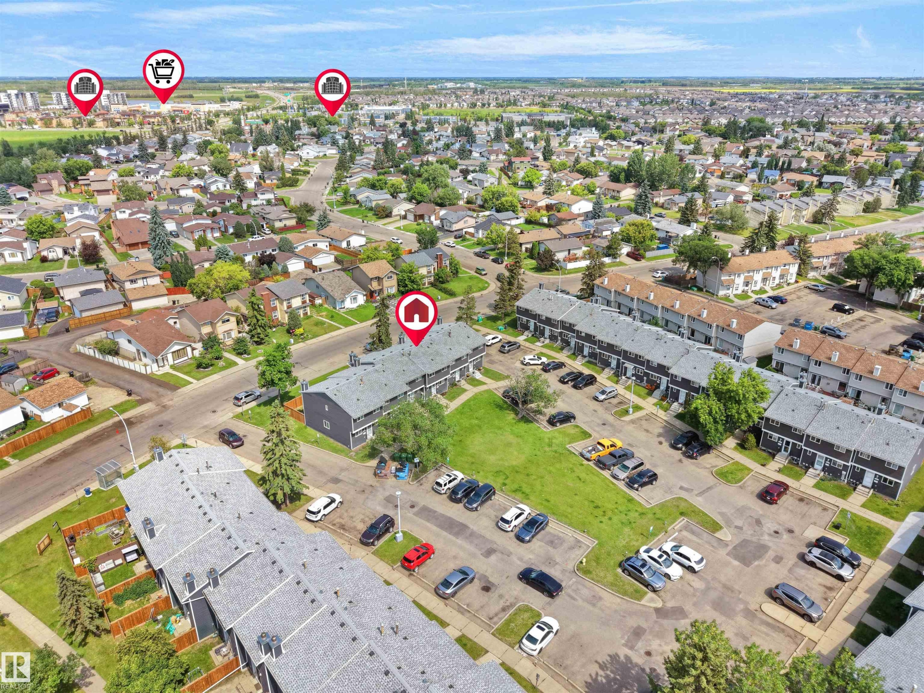 Aerial perspective showcasing a residential community with various housing types, including multi-unit buildings with shingle roofs - 575 Dunluce Road, Edmonton, AB
