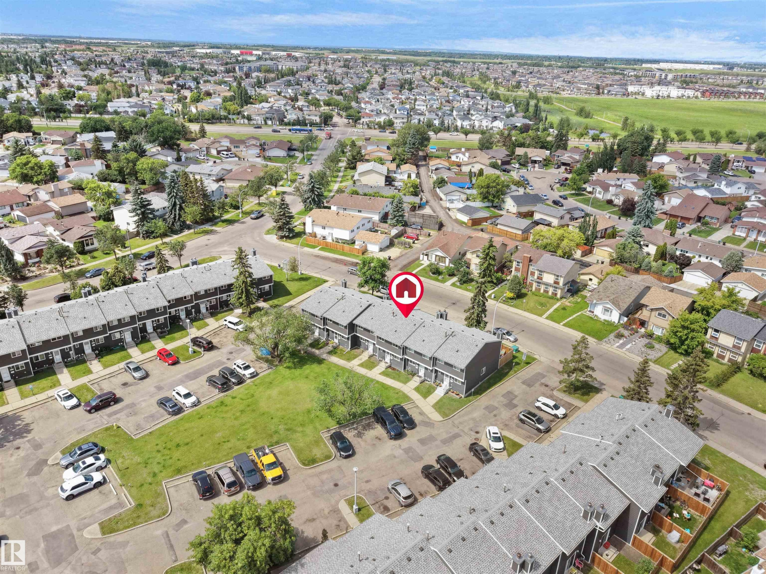 Aerial perspective highlighting two-story townhomes with gray exteriors and shingled roofs - 575 Dunluce Road, Edmonton, AB