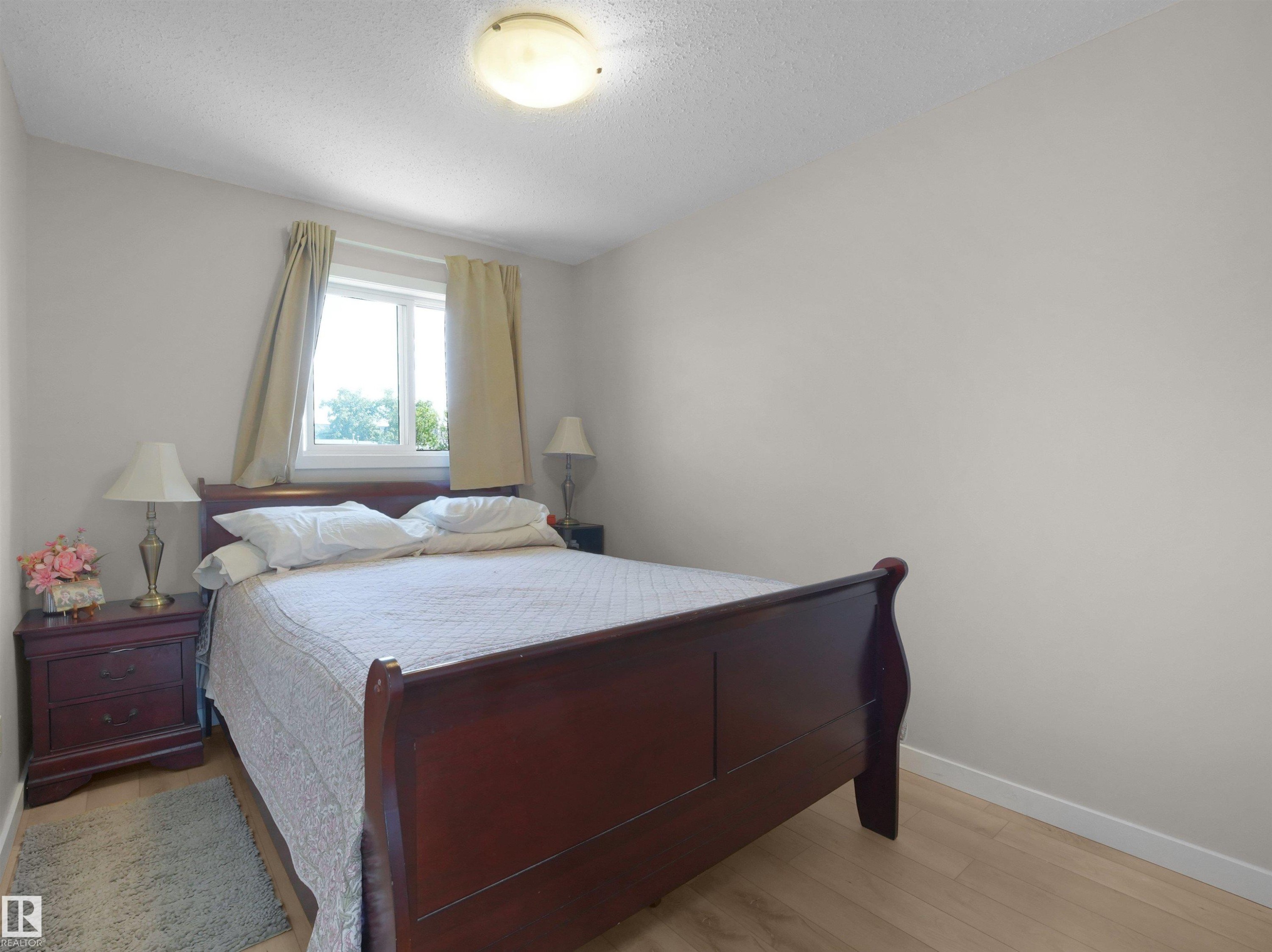Light-toned wood-finish flooring provides a bright foundation for this room, complemented by neutral wall tones - 575 Dunluce Road, Edmonton, AB