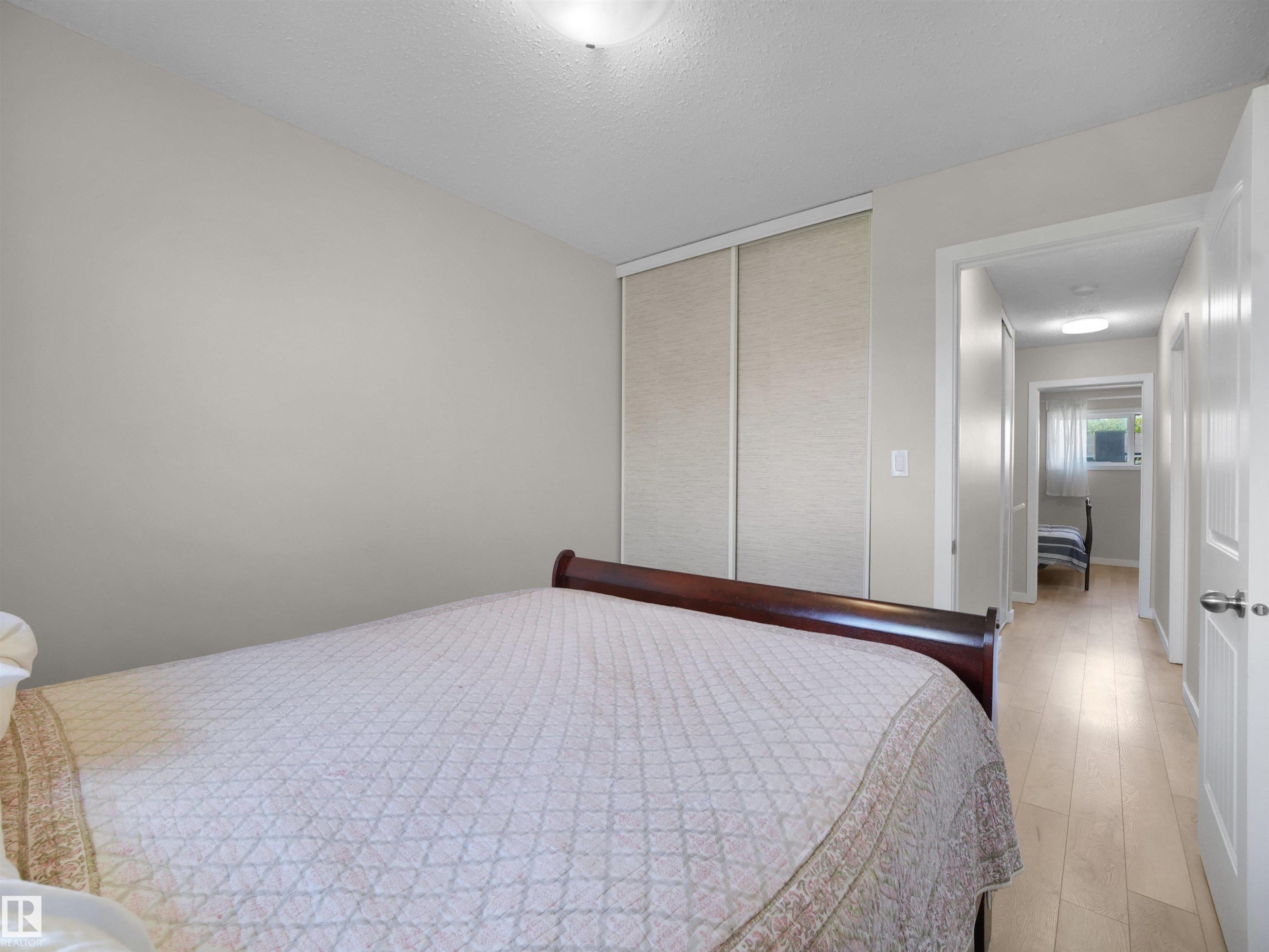 Bedroom featuring light neutral wall paint and wood-finish flooring - 575 Dunluce Road, Edmonton, AB