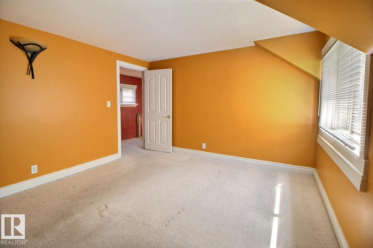 Carpeted room with orange walls and white trim - 11312 127 Street Nw, Edmonton, AB