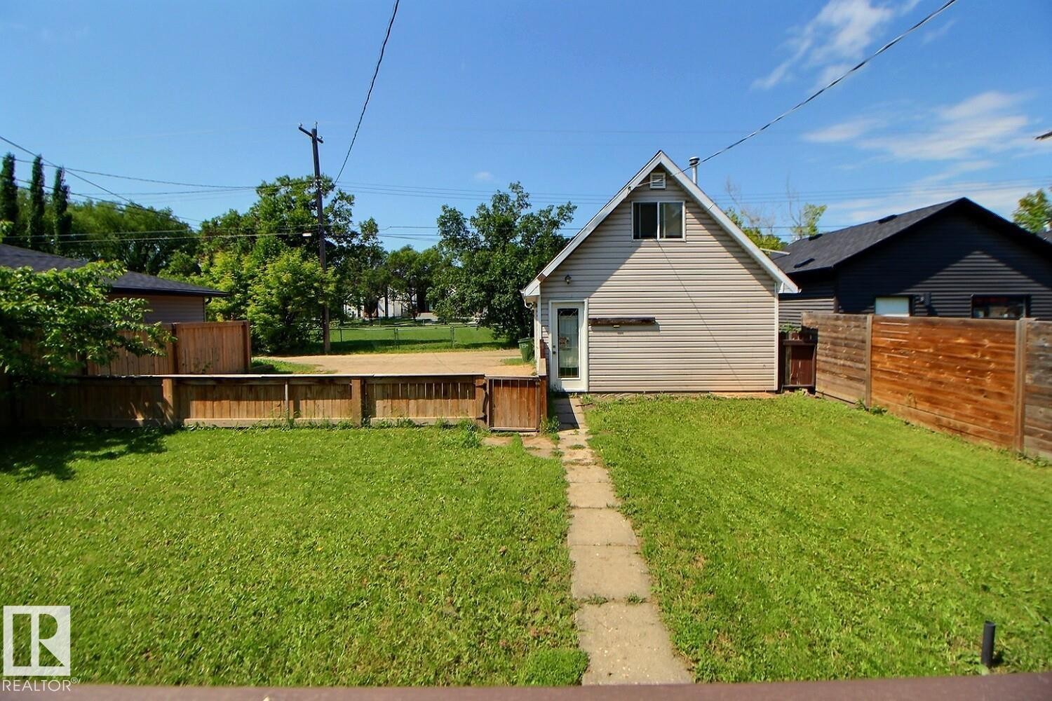 Expansive grassy yard area with partial wood fencing - 11312 127 Street Nw, Edmonton, AB