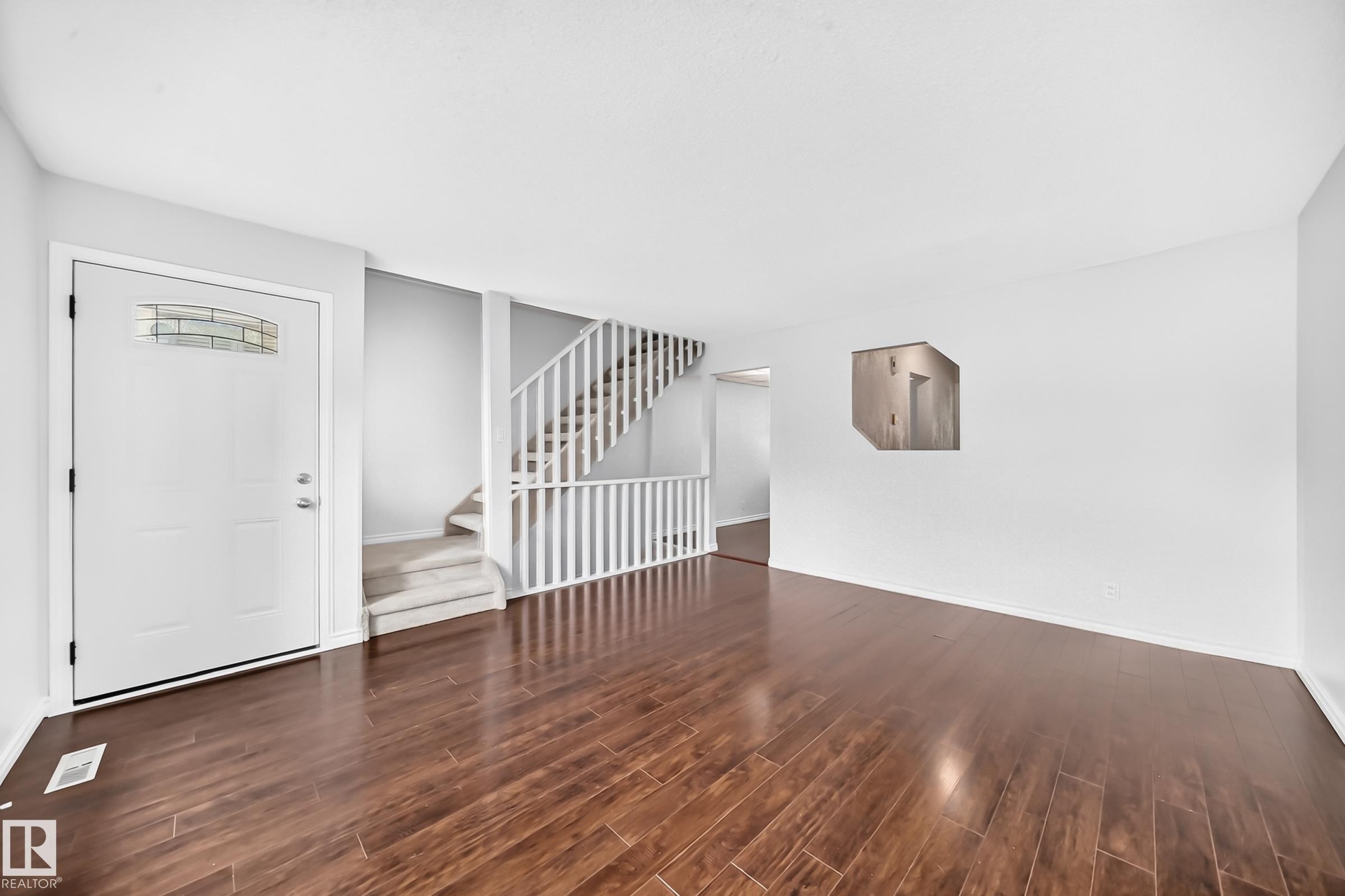 Spacious living area featuring rich wood-finish flooring - 11447 22 Avenue Nw, Edmonton, AB - Indoor Photo Showing Other Room