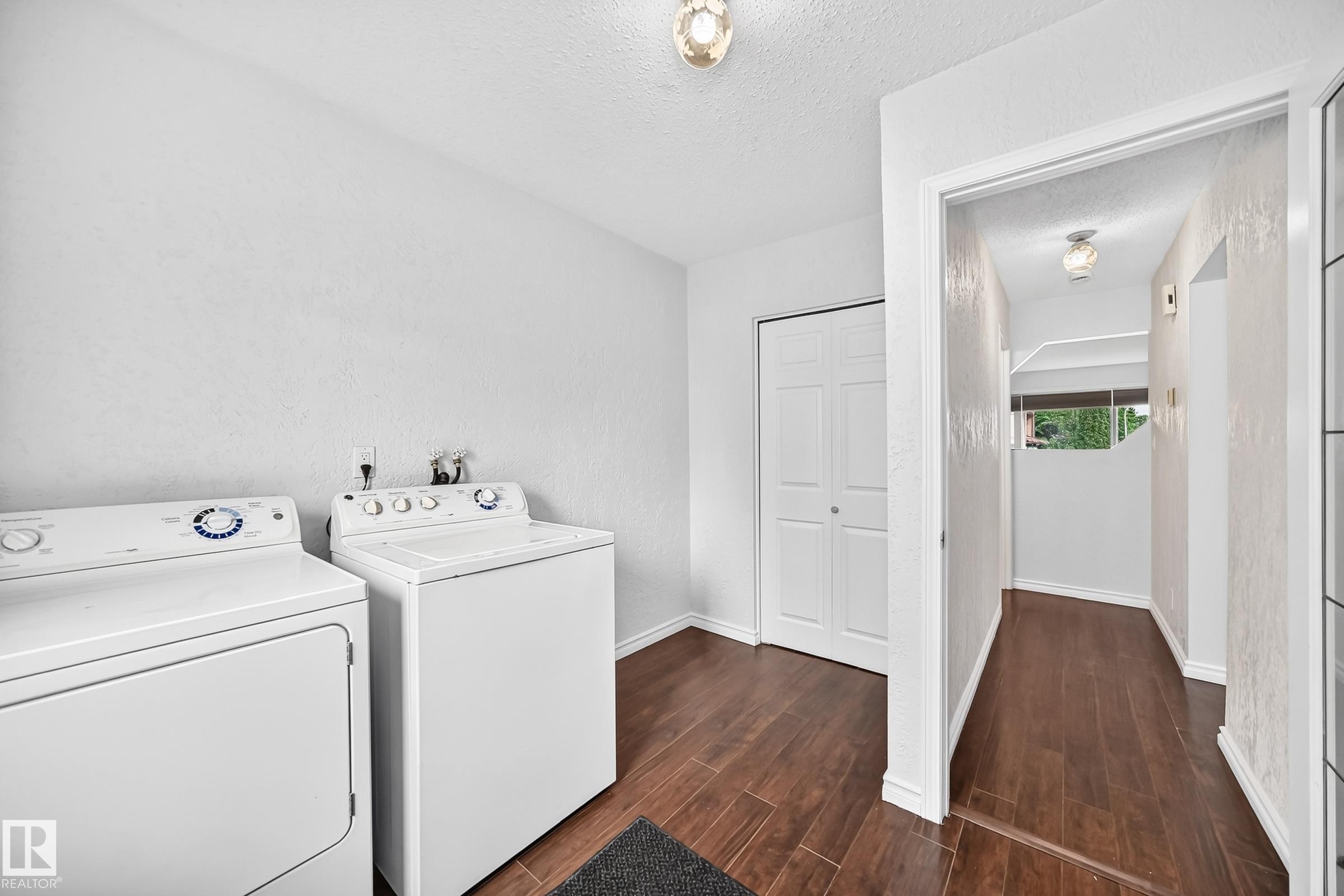 Dedicated laundry area featuring wood-finish flooring, overhead lighting, and white walls - 11447 22 Avenue Nw, Edmonton, AB - Indoor Photo Showing Laundry Room