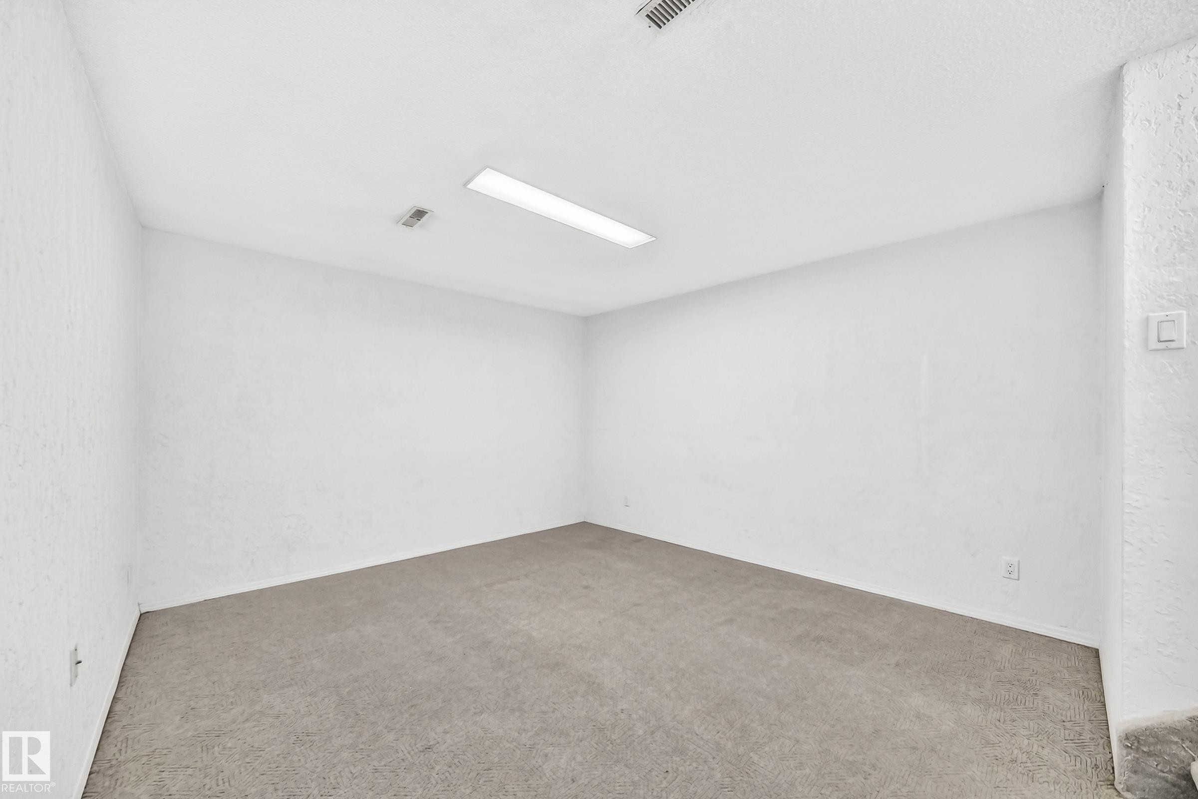 Spacious room featuring neutral carpeting, white painted walls, and a white ceiling with recessed lighting - 11447 22 Avenue Nw, Edmonton, AB - Indoor Photo Showing Other Room