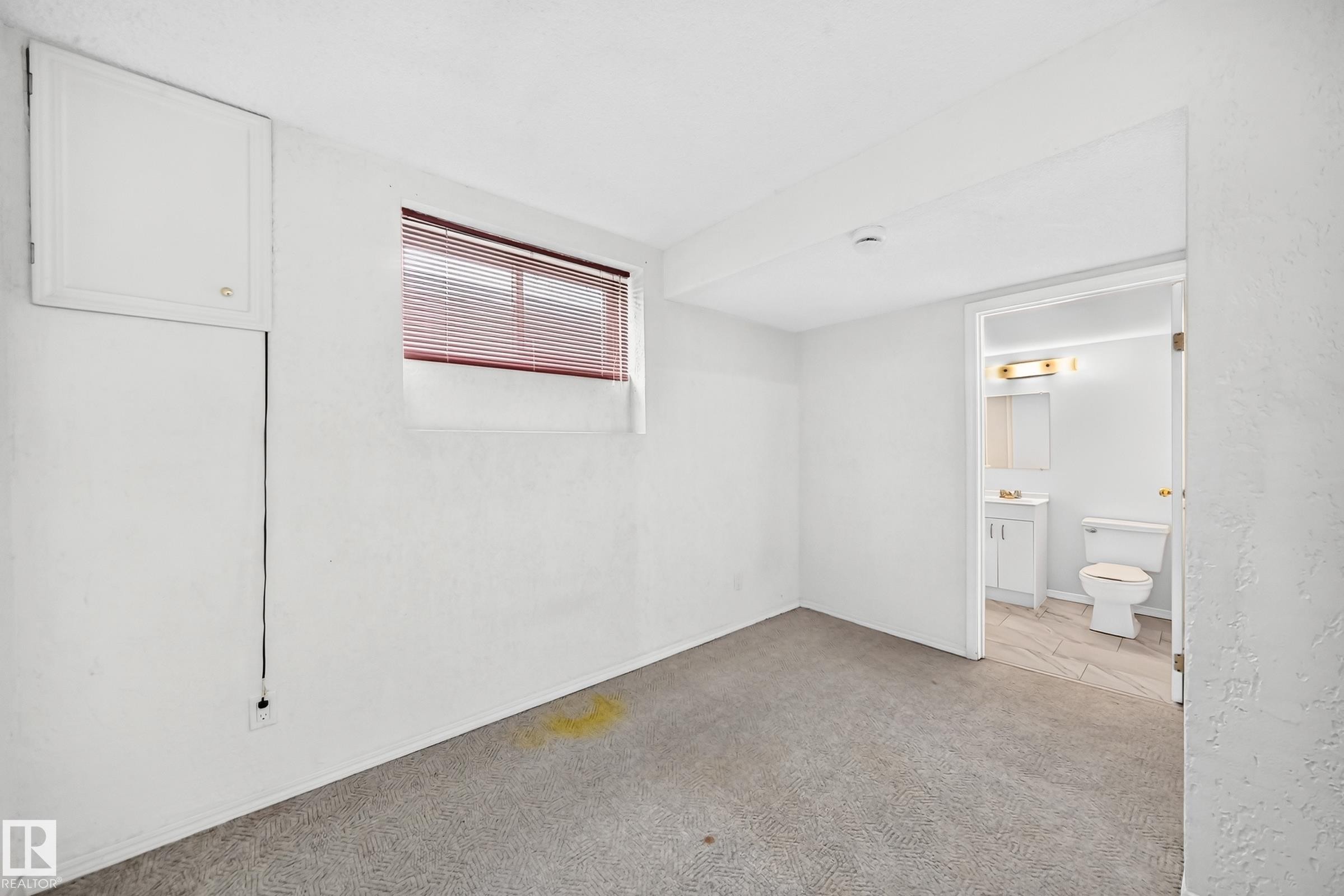 Carpeted room with a horizontal window featuring blinds - 11447 22 Avenue Nw, Edmonton, AB - Indoor Photo Showing Other Room