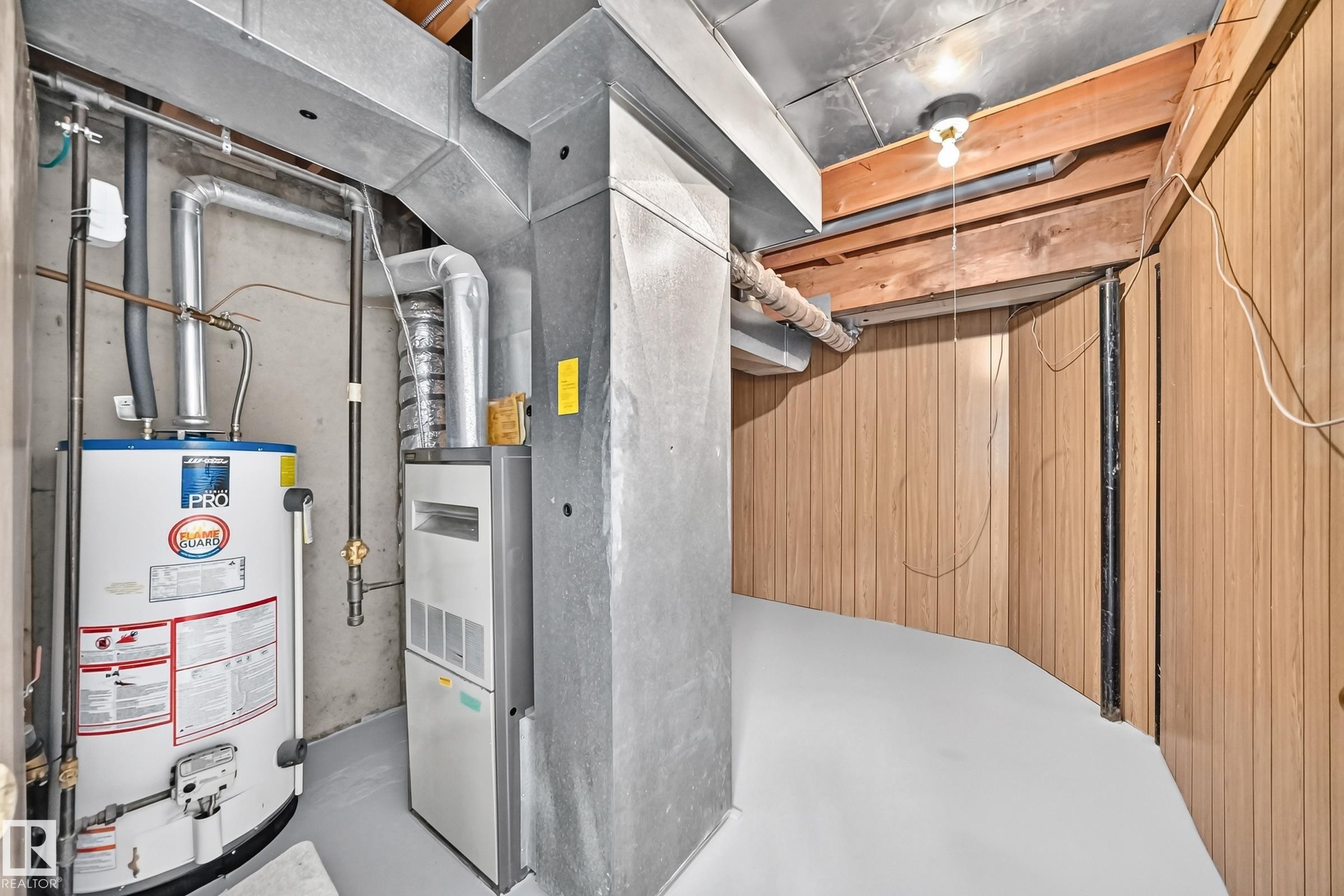 Utility area featuring a water heater, furnace, and exposed ceiling joists - 11447 22 Avenue Nw, Edmonton, AB - Indoor Photo Showing Basement