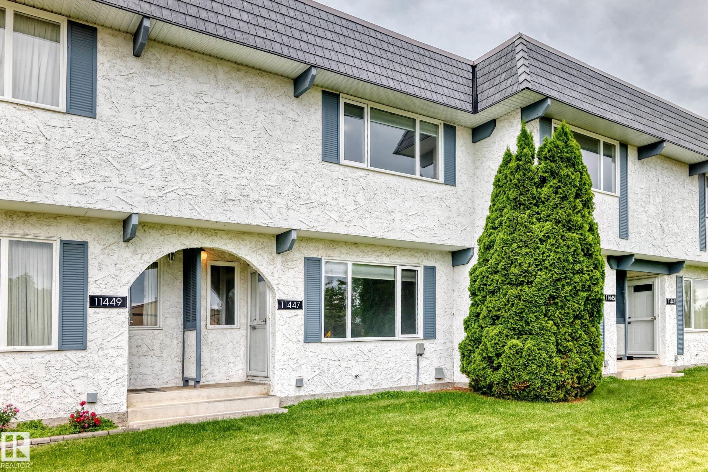 Stucco exterior with a peaked roofline and white window frames - 11447 22 Avenue Nw, Edmonton, AB - Outdoor