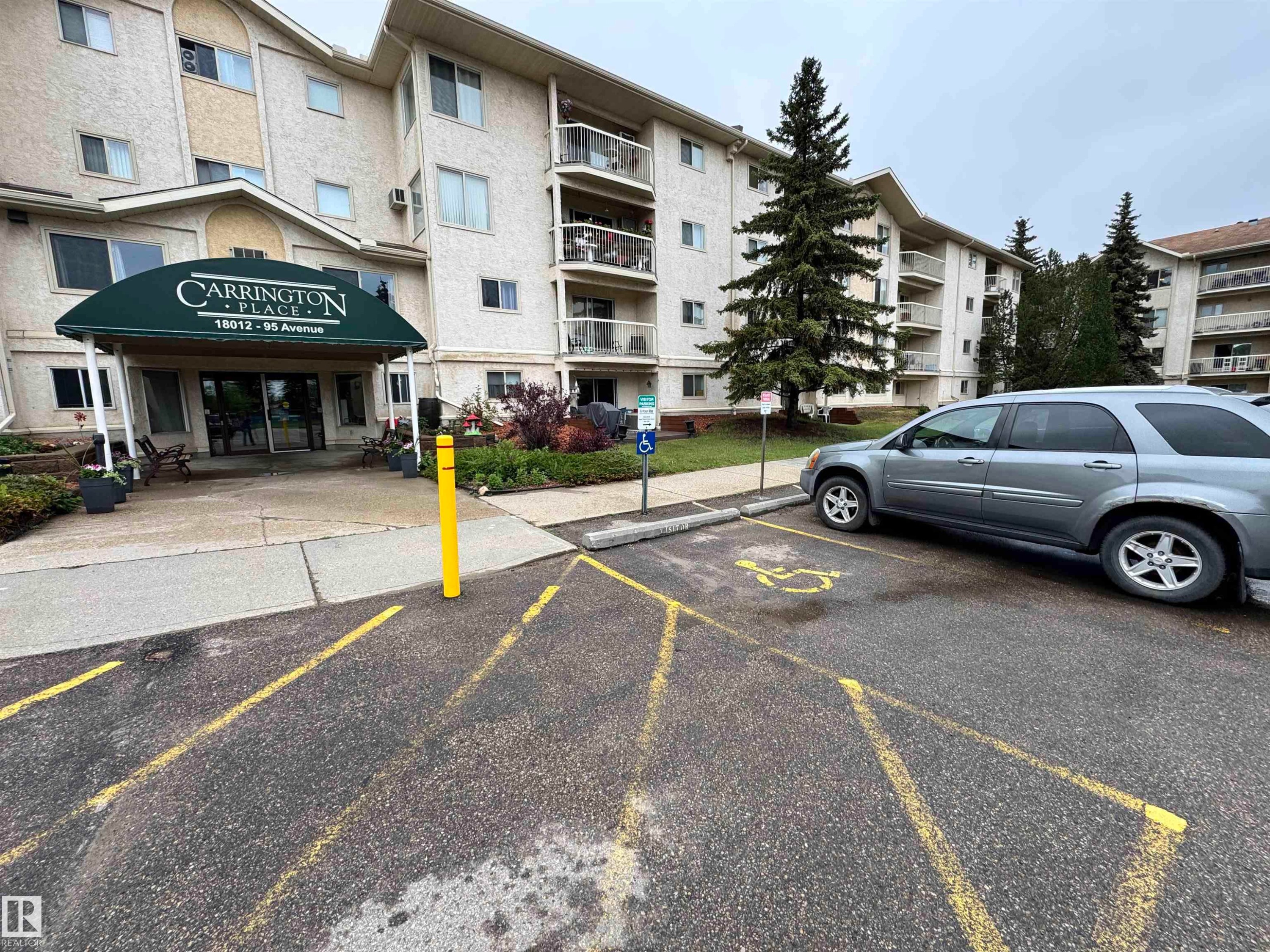 Multi-story residential building with light-colored stucco exterior and numerous private balconies - 207 18012 95 Avenue, Edmonton, AB
