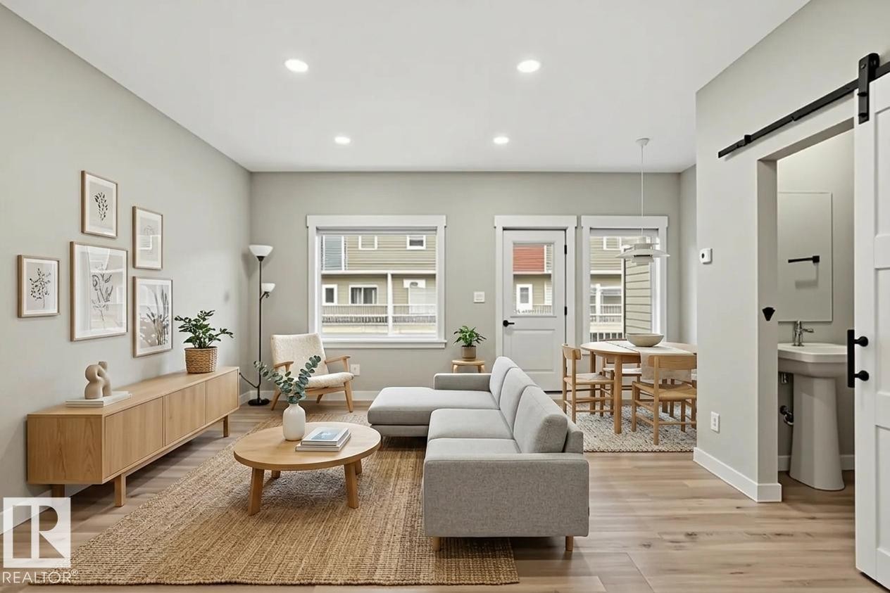 Open-concept living area featuring wood-finish flooring, recessed lighting, and a neutral color palette - 36 150 Everitt Dr, St. Albert, AB - Indoor Photo Showing Living Room