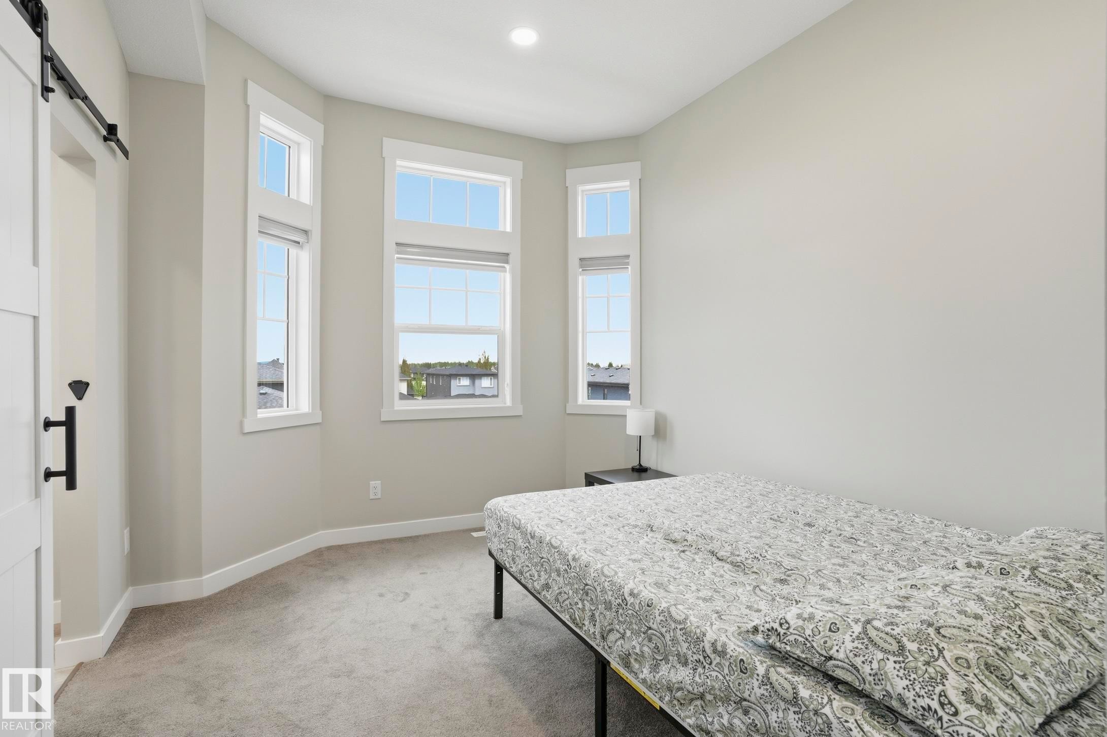 Room featuring a bay window with multiple vertical windows, light gray walls, recessed lighting, and gray carpet - 36 150 Everitt Dr, St. Albert, AB - Indoor Photo Showing Bedroom