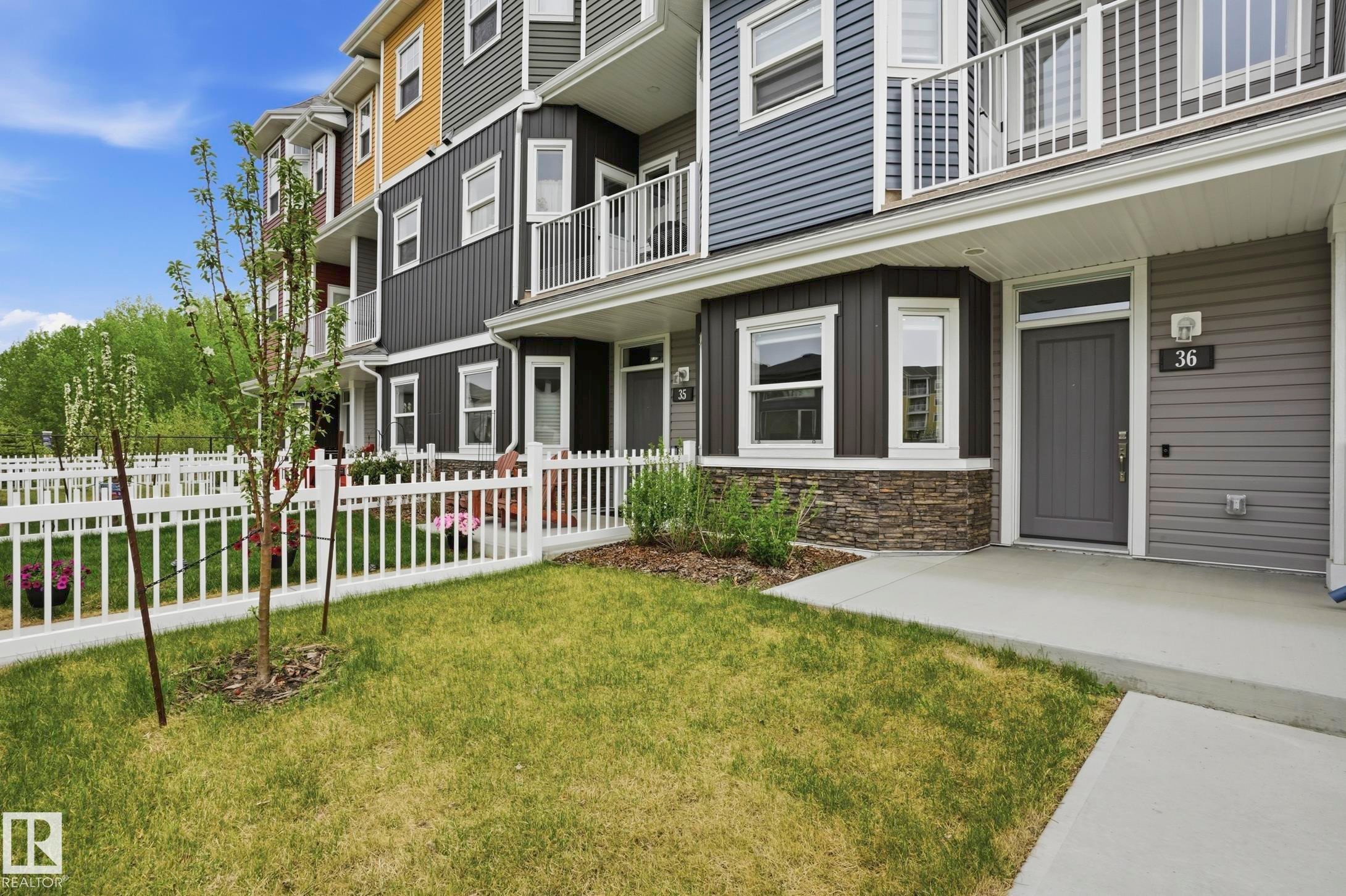 Townhome exterior featuring multi-toned siding, white trim windows, and private balconies with white railings - 36 150 Everitt Dr, St. Albert, AB - Outdoor With Balcony