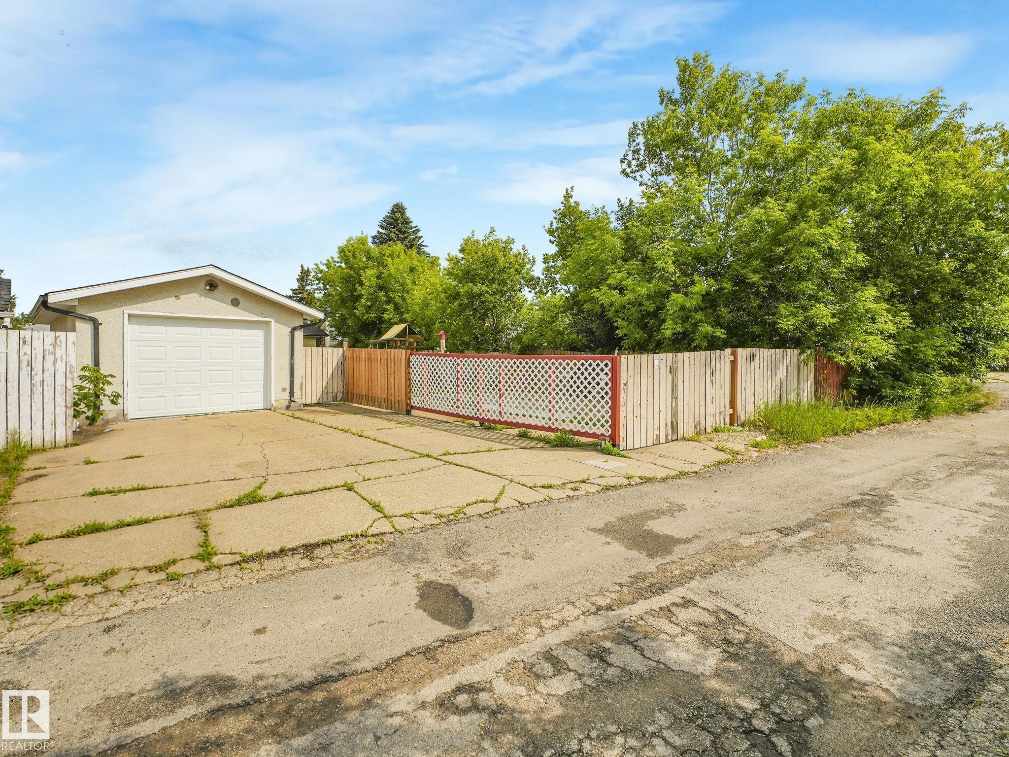 Detached garage featuring an overhead door and a stucco exterior finish - 9315 151 Avenue, Edmonton, AB