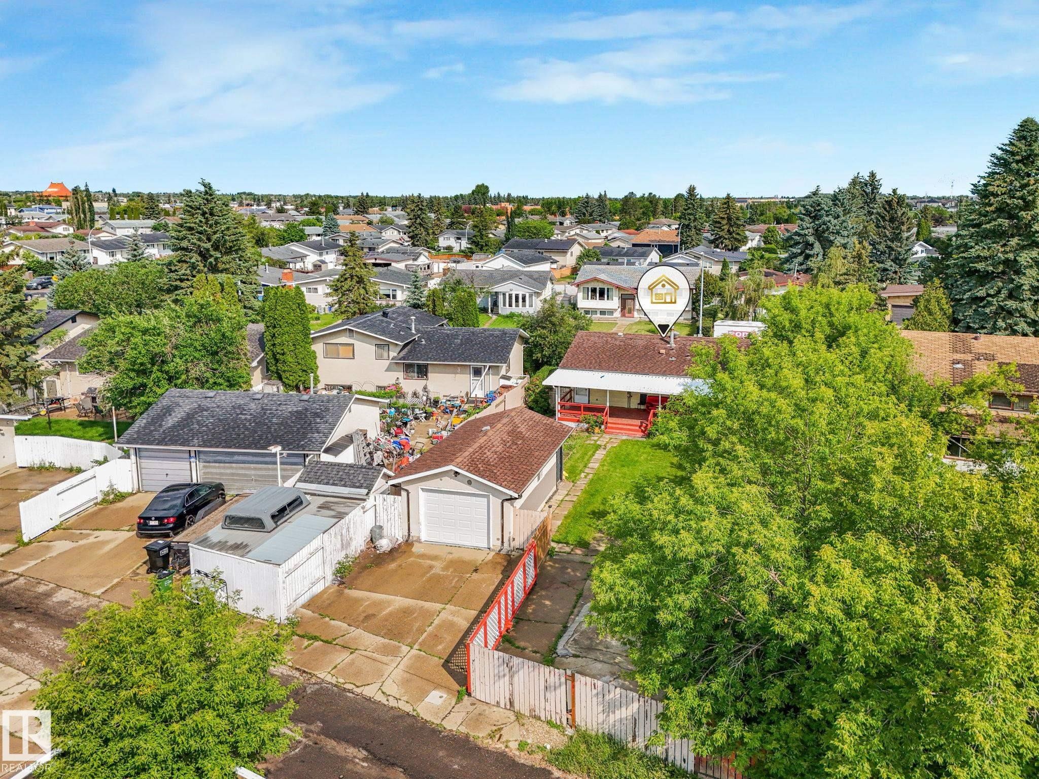 Single-family residence with a red exterior and a covered front porch - 9315 151 Avenue, Edmonton, AB