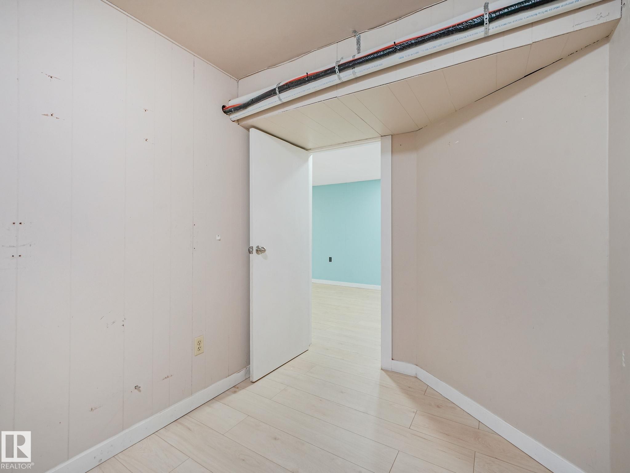 Interior space featuring light wood-finish flooring and a white paneled wall - 9315 151 Avenue, Edmonton, AB