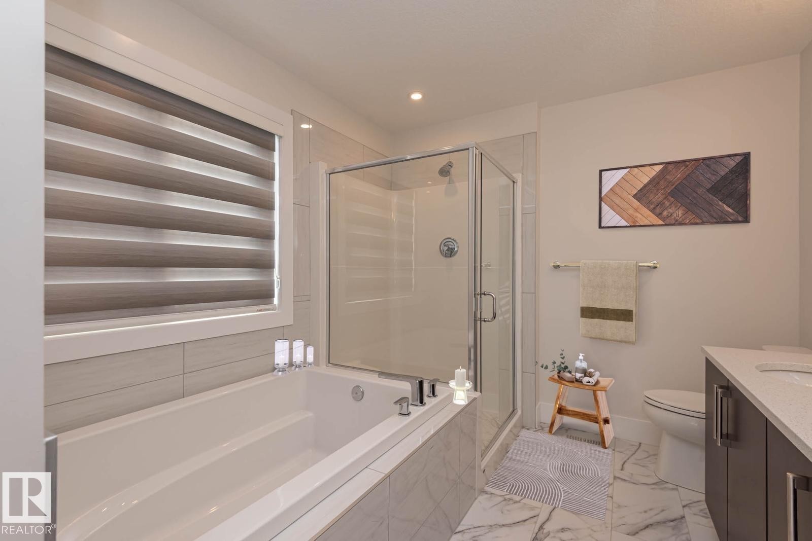 Bathroom featuring a built-in soaking tub, glass-enclosed shower, and a single vanity with a solid surface countertop - 2635 Donaghey Crescent, Edmonton, AB