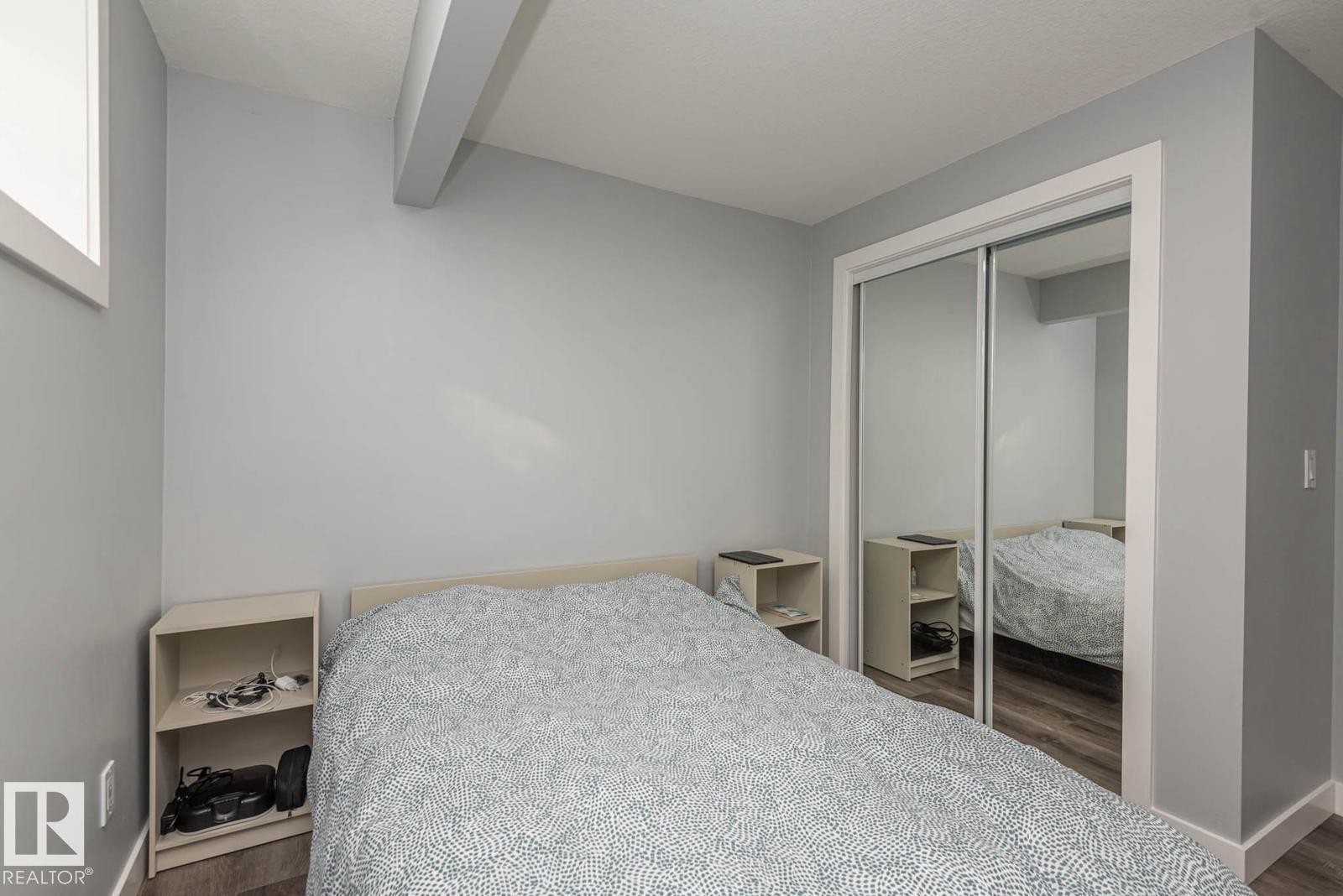 Room featuring wood-finish flooring, light grey painted walls, and white trim - 2635 Donaghey Crescent, Edmonton, AB