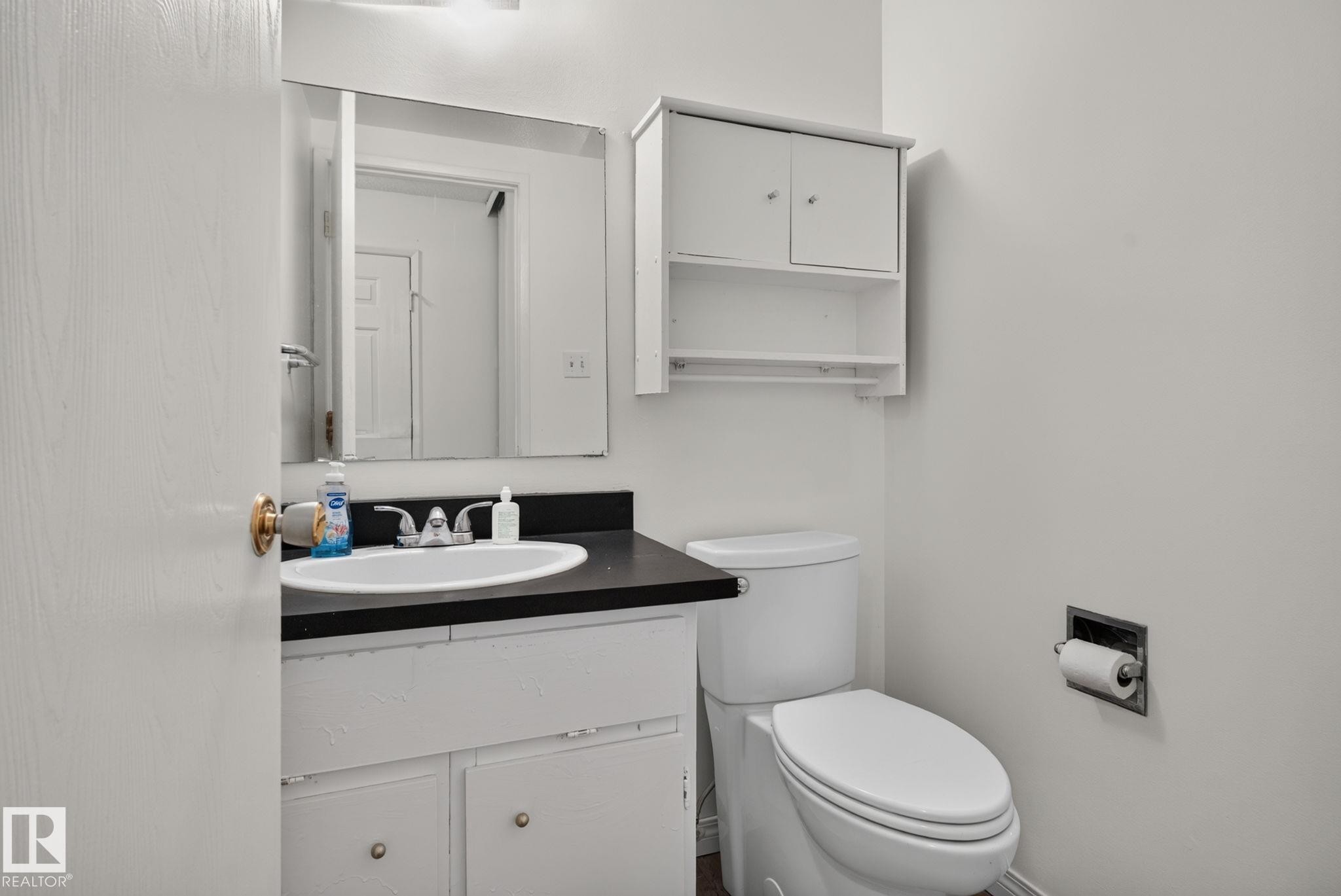 Bathroom vanity with a dark countertop and integrated sink - 9503 180A Street Nw, Edmonton, AB - Indoor Photo Showing Bathroom