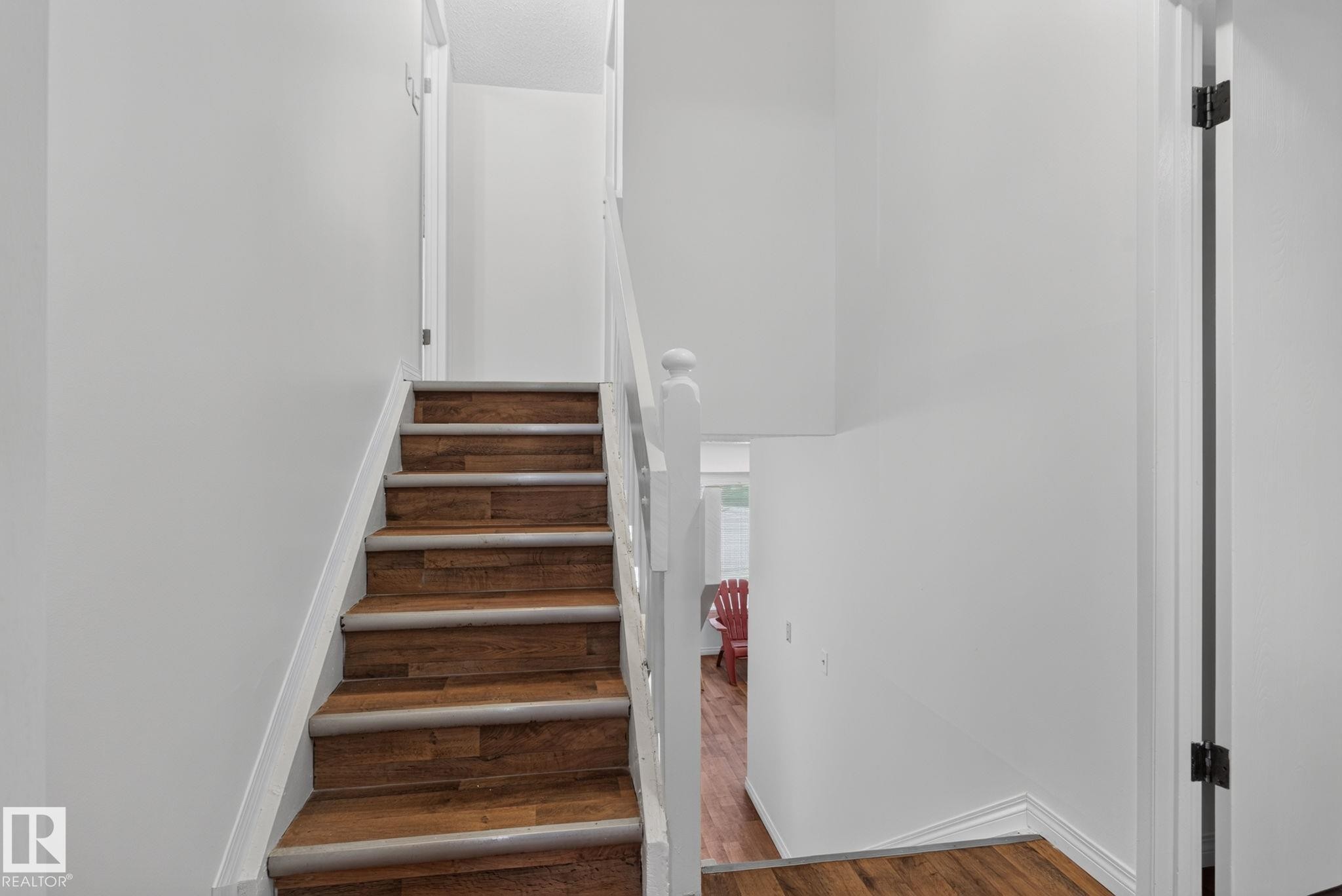 Staircase featuring wood-finish treads and risers, white painted balusters and handrail, and white wall finishes - 9503 180A Street Nw, Edmonton, AB - Indoor Photo Showing Other Room