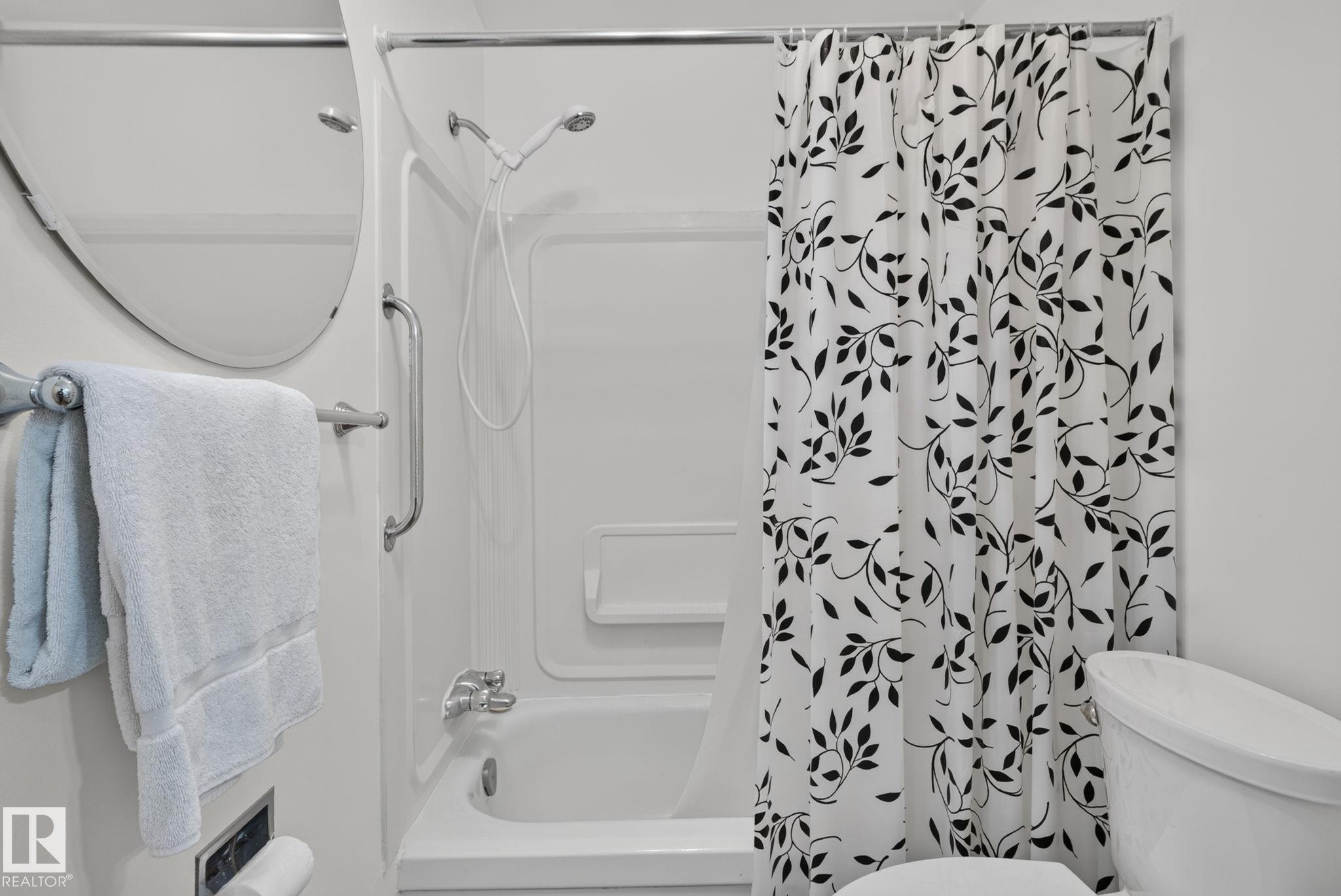 White acrylic tub and shower combination with a handheld showerhead - 9503 180A Street Nw, Edmonton, AB - Indoor Photo Showing Bathroom