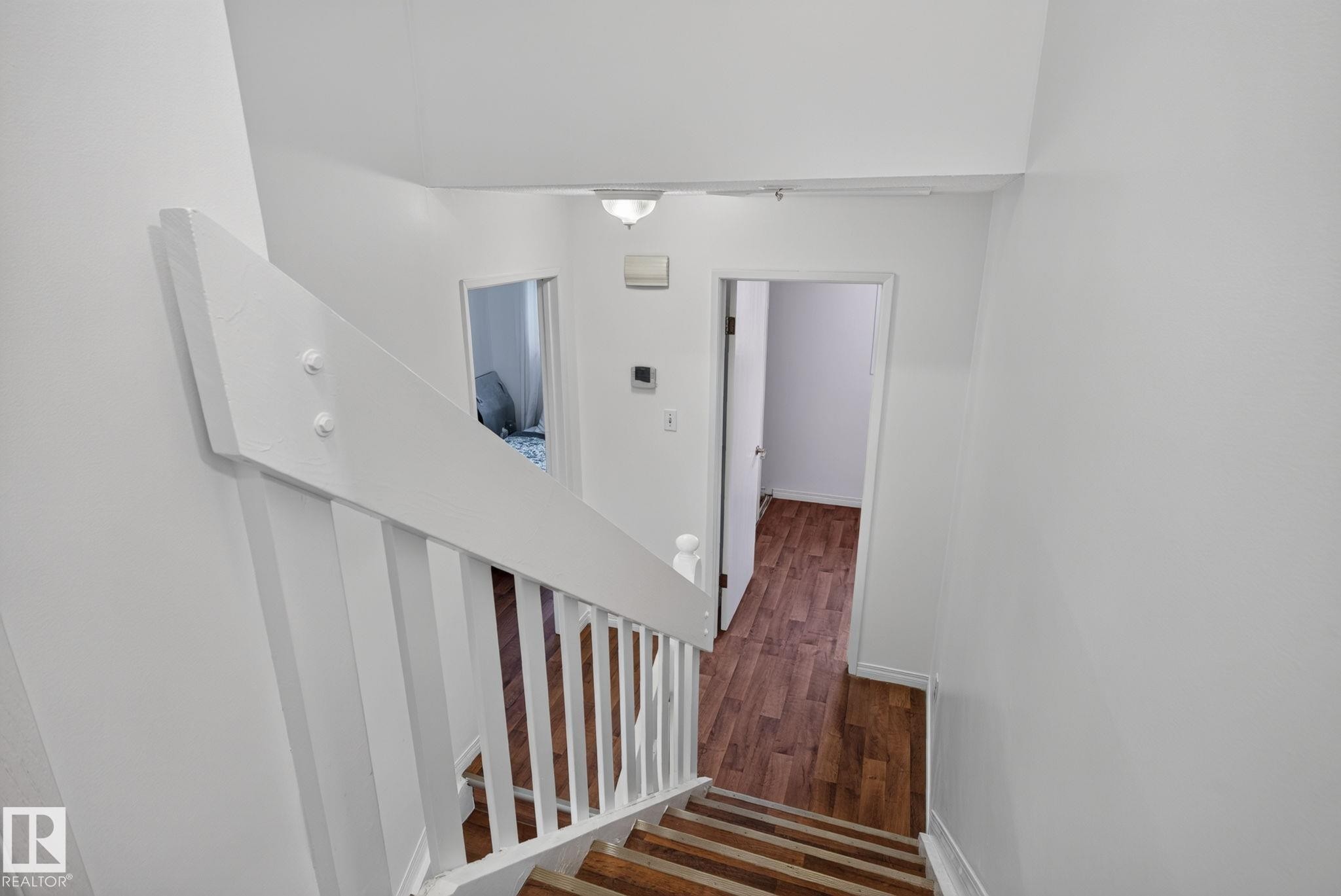 Staircase featuring wood-finish treads and white painted balusters - 9503 180A Street Nw, Edmonton, AB - Indoor Photo Showing Other Room