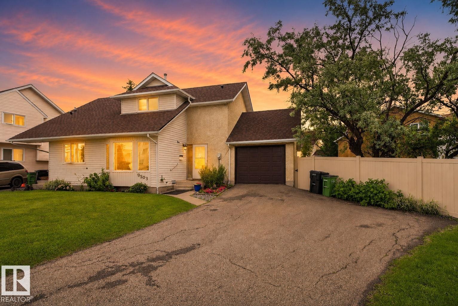 Two-story residence featuring a brown shingle roof, light-colored siding, and a prominent front-facing dormer - 9503 180A Street Nw, Edmonton, AB - Outdoor