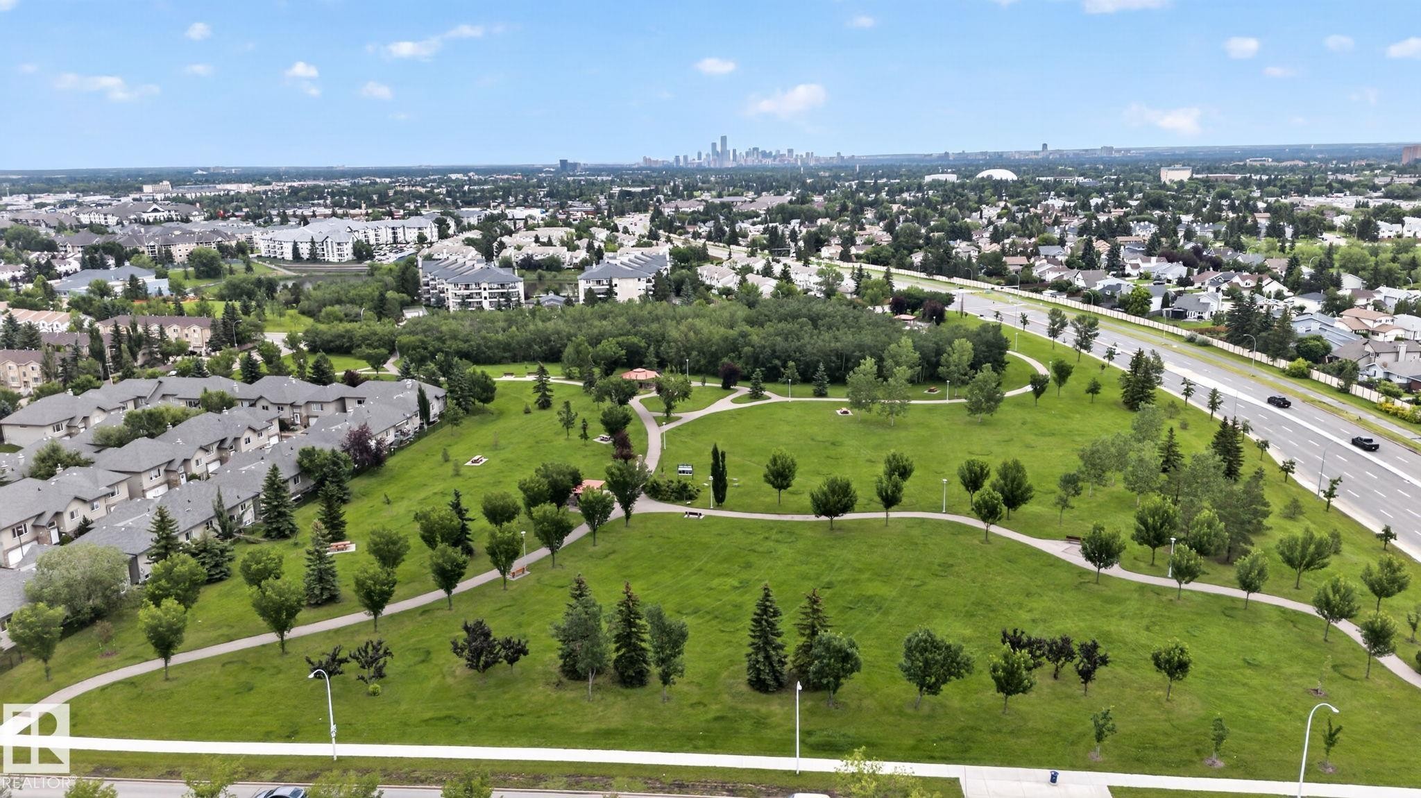 Expansive green space featuring mature trees and paved walking paths - 9503 180A Street Nw, Edmonton, AB - Outdoor With View