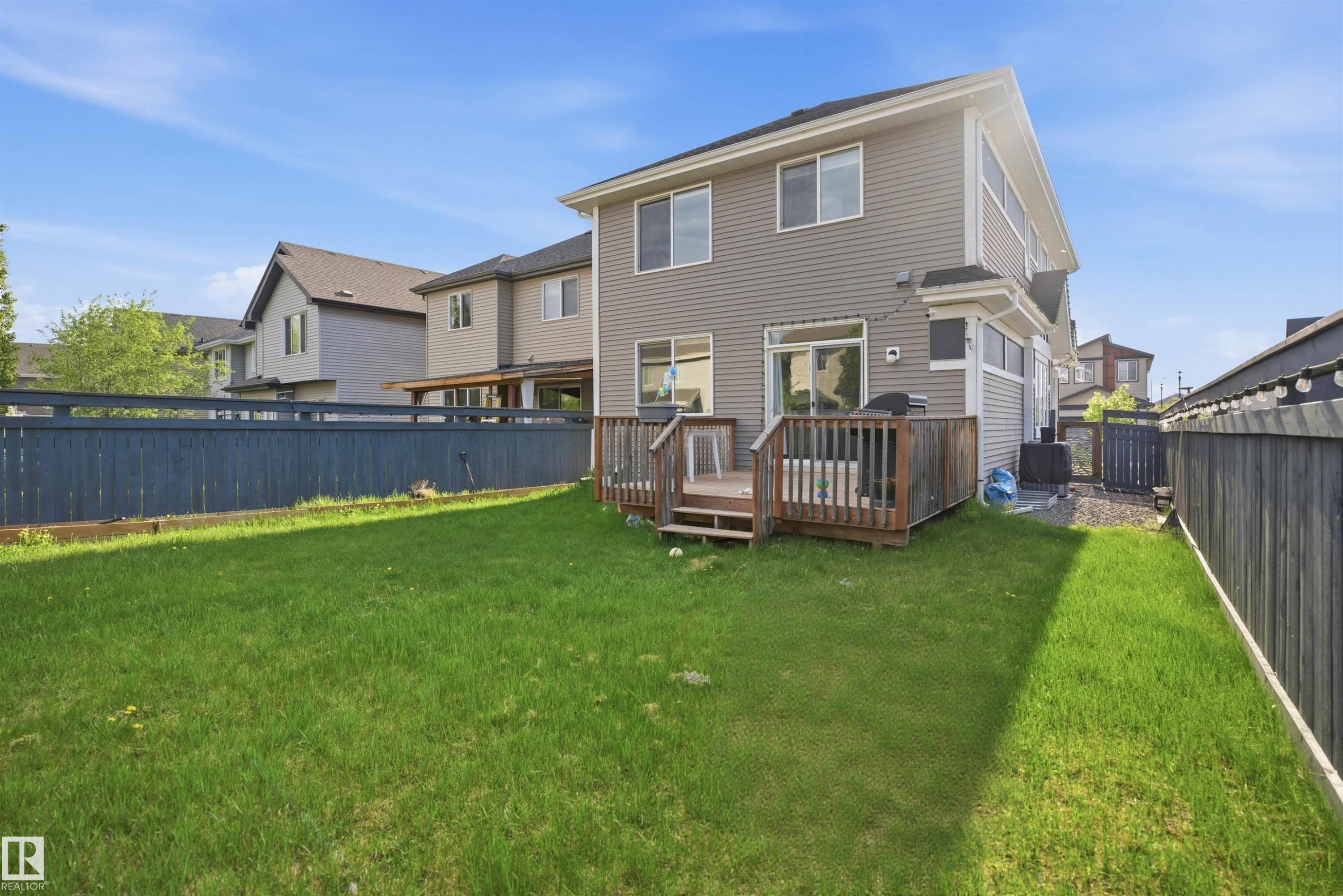 Expansive rear yard featuring a manicured lawn and a multi-level wood deck - 1234 Daniels Crescent, Edmonton, AB - Outdoor