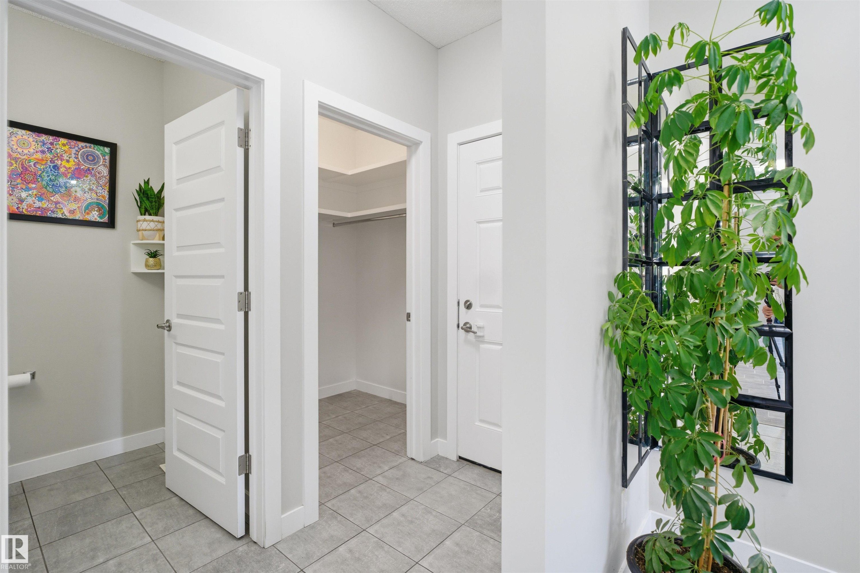 Entryway featuring light gray tile flooring, crisp white trim, and white paneled doors - 1234 Daniels Crescent, Edmonton, AB - Indoor Photo Showing Other Room