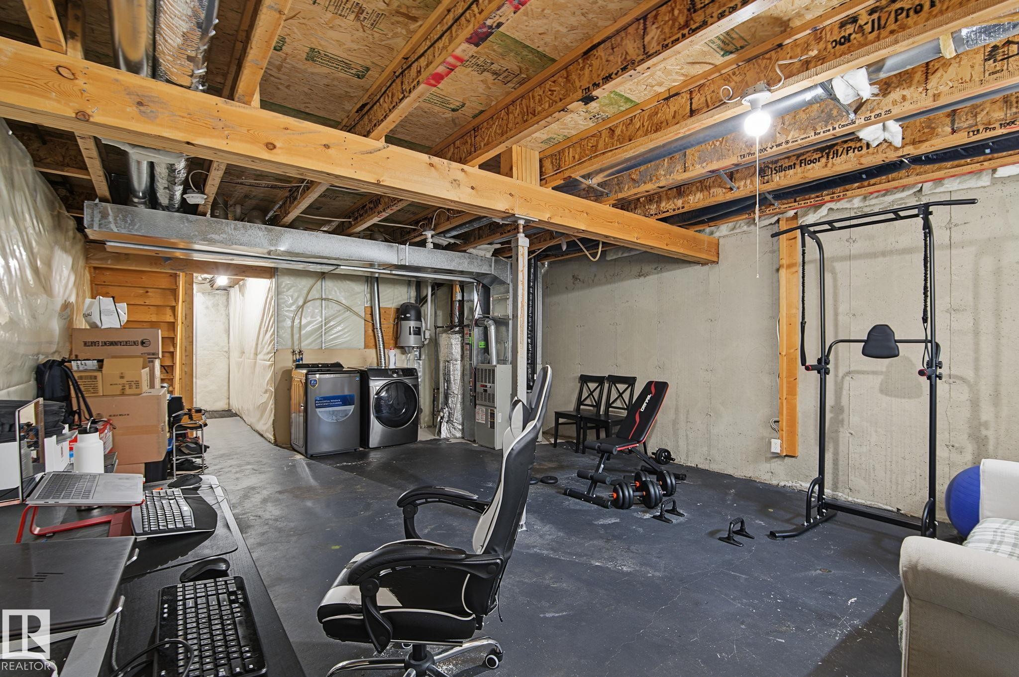 Unfinished basement with exposed ceiling joists and concrete walls - 5 14603 Miller Boulevard, Edmonton, AB
