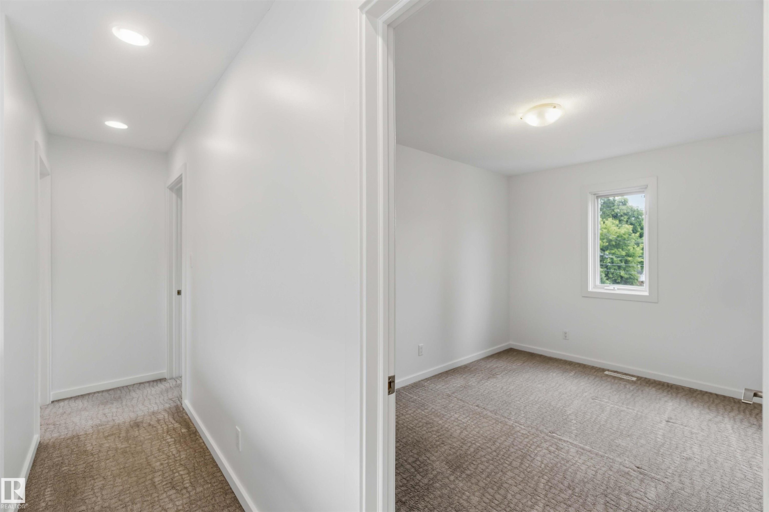 Hallway with recessed lighting, white walls, and patterned carpet flooring - #1 14315 Stony Plain Nw, Edmonton, AB - Indoor Photo Showing Other Room